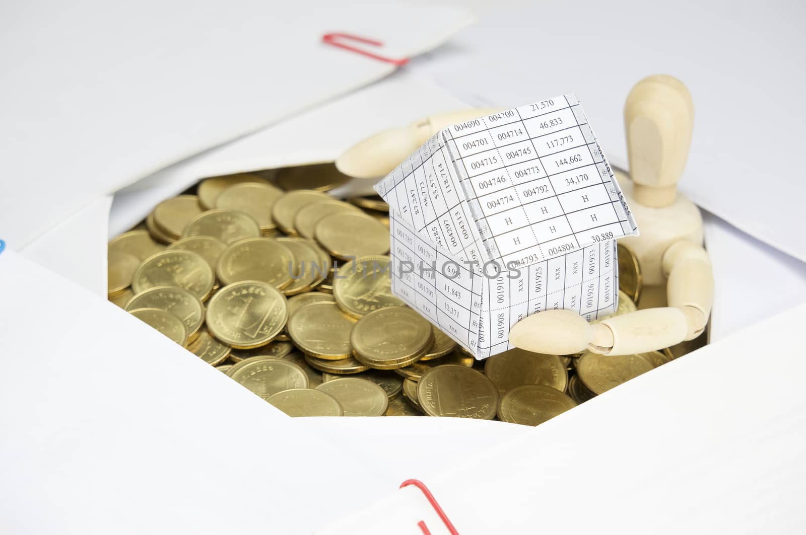 Wooden dummy holding house surrounded by gold coins and paperwork by eaglesky