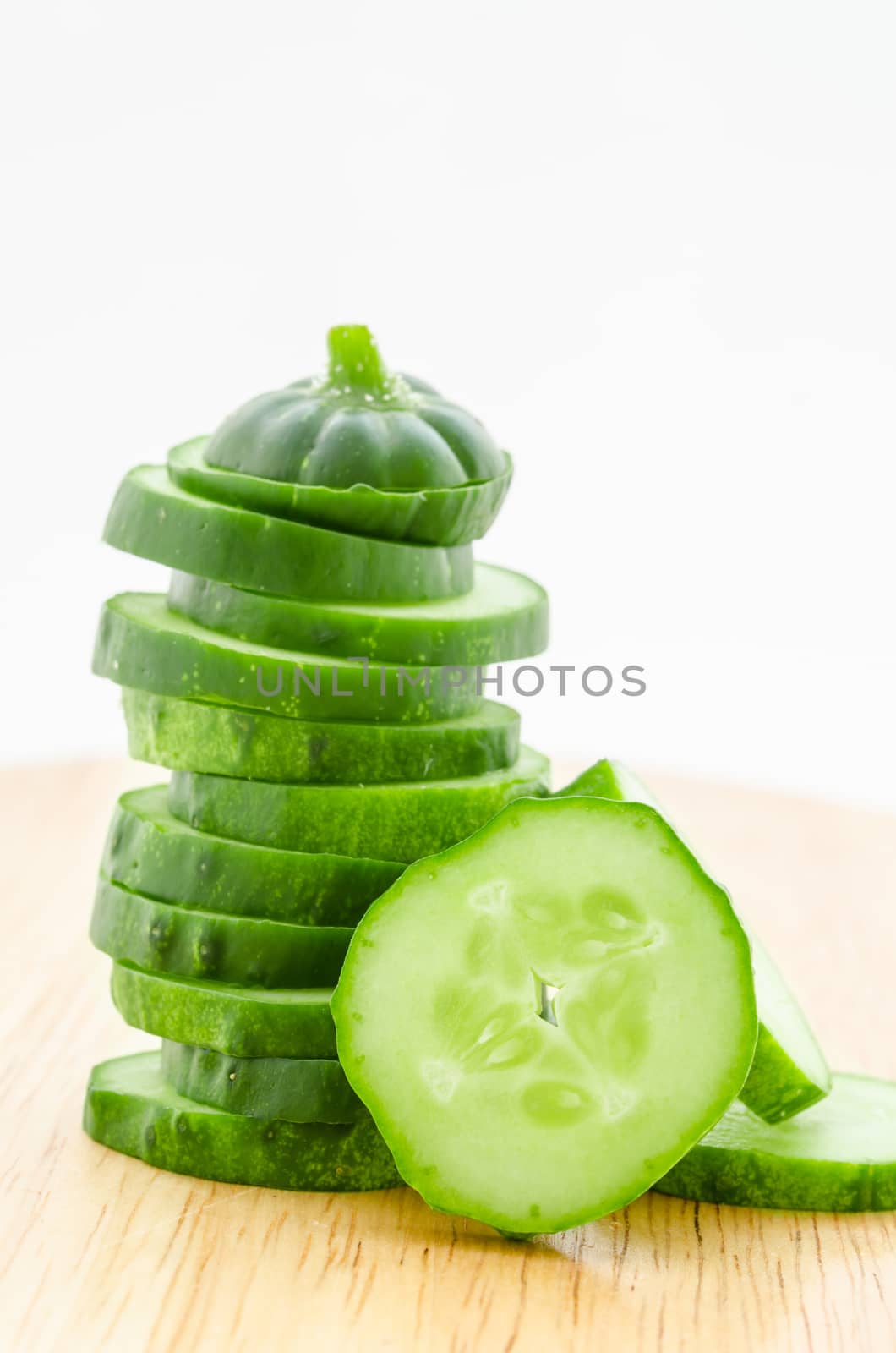 Cucumber and slices on wooden table.