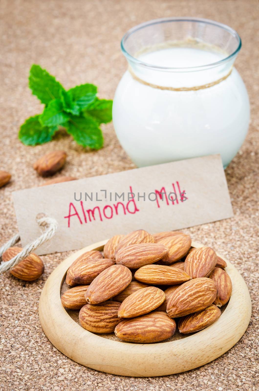 Almond and almond milk on wooden table.