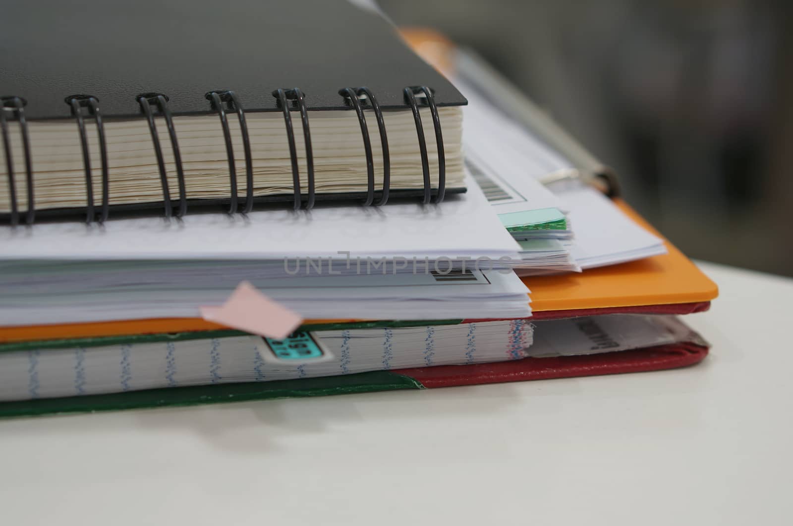 Stack of report book and document placed on desk in office.