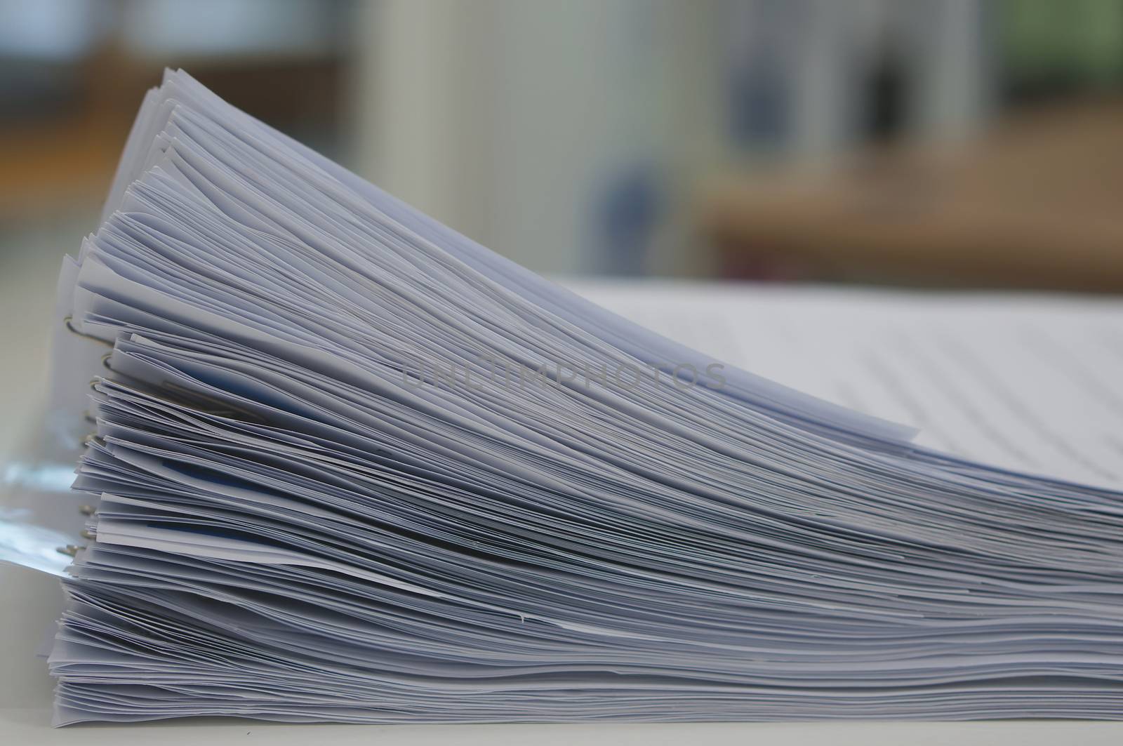 Stack of many  document organized by clipping placed on desk in office.