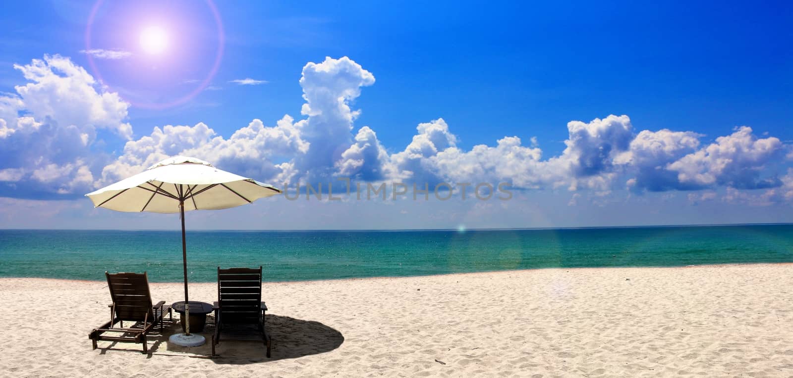 Beach chair and umbrella near the beach with blue sky