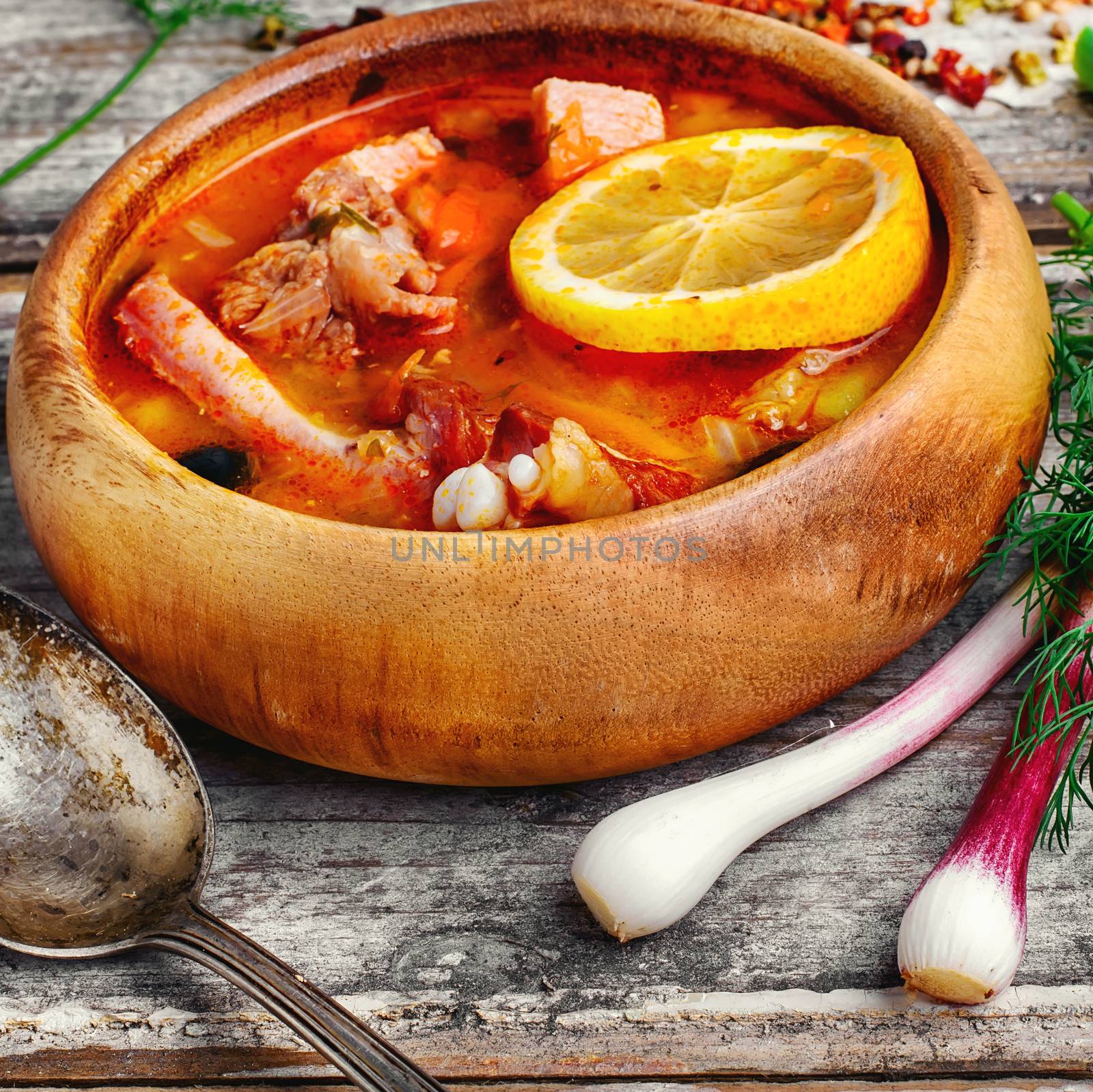 Traditional Solyanka with smoked meats in wooden plate