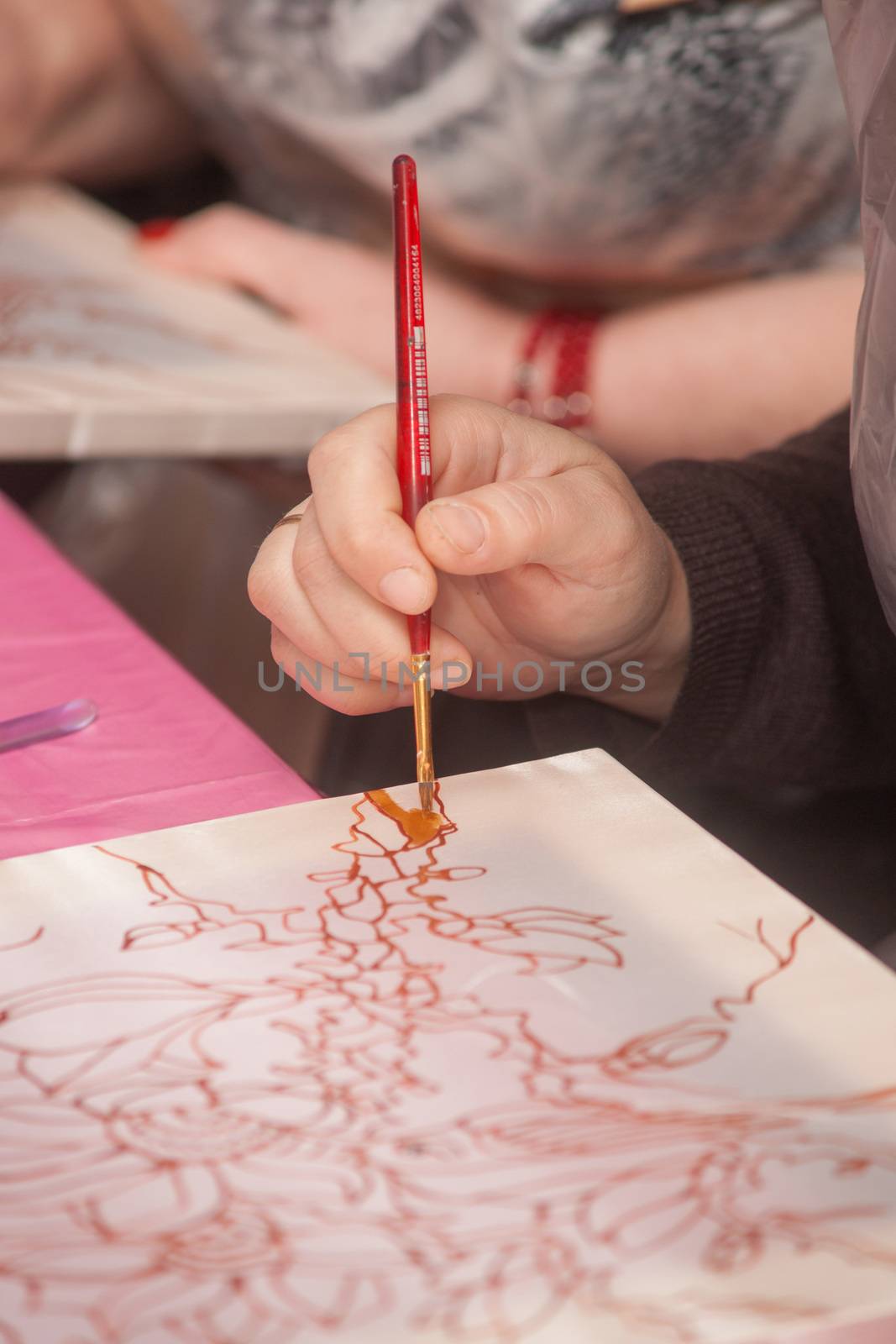 A woman hand with pencil is drawing picture with flowers