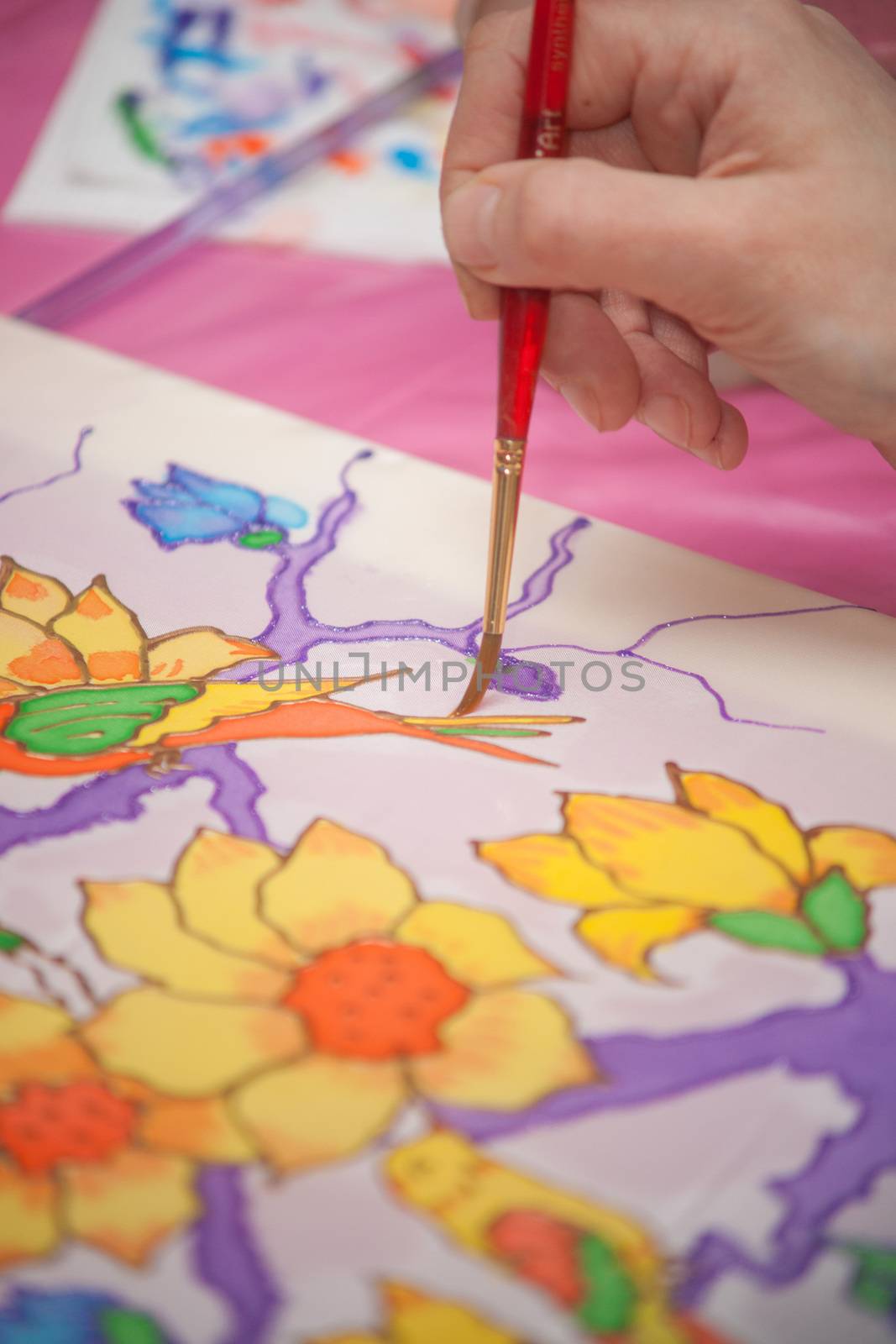 A woman hand with pencil is drawing picture with flowers