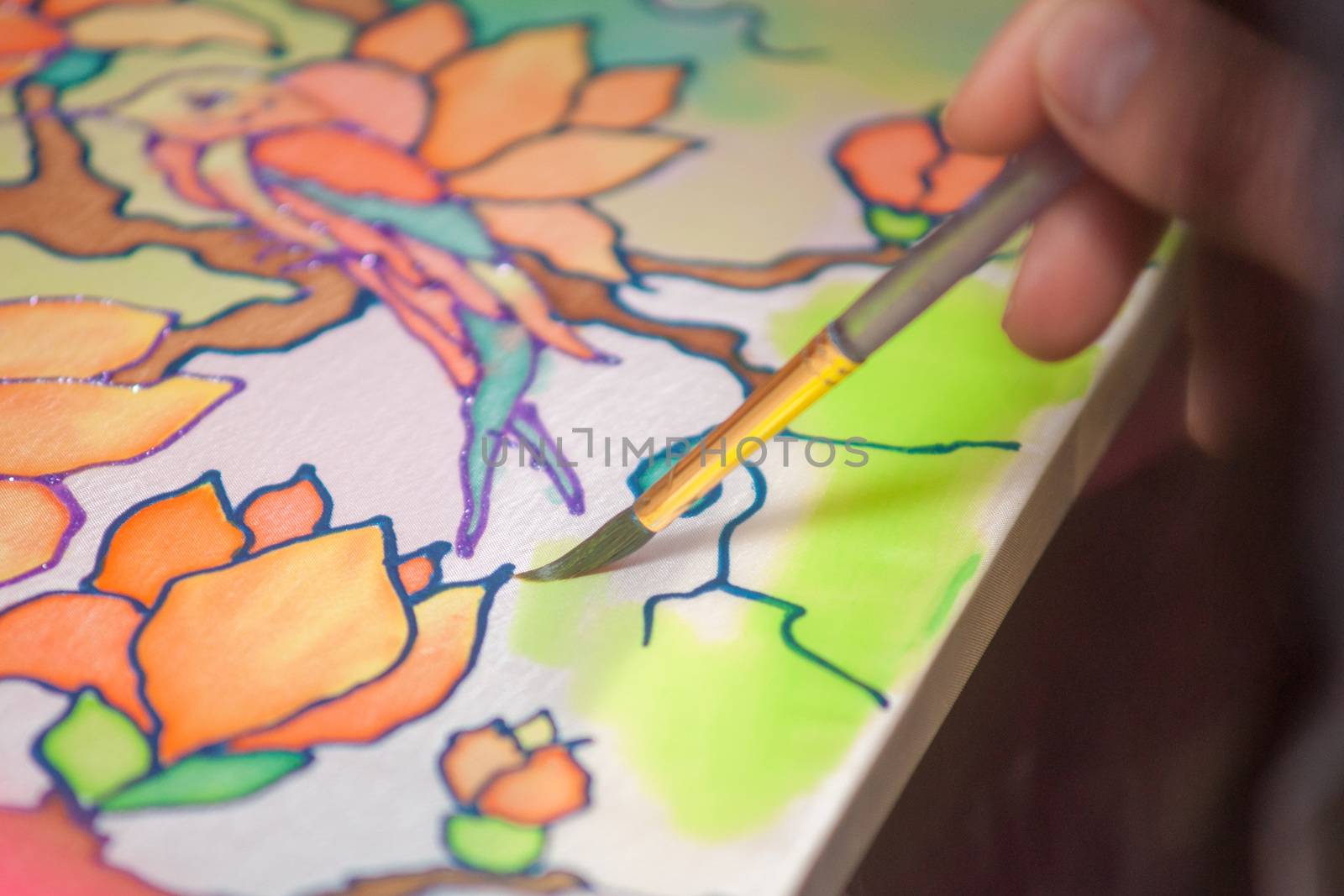 A woman hand with pencil is drawing picture with flowers