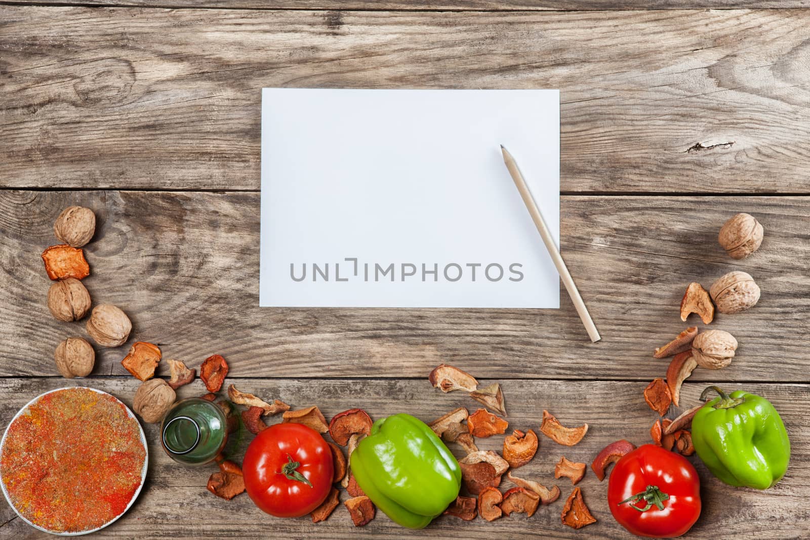 Blank recipe paper on wooden background with vegetables
