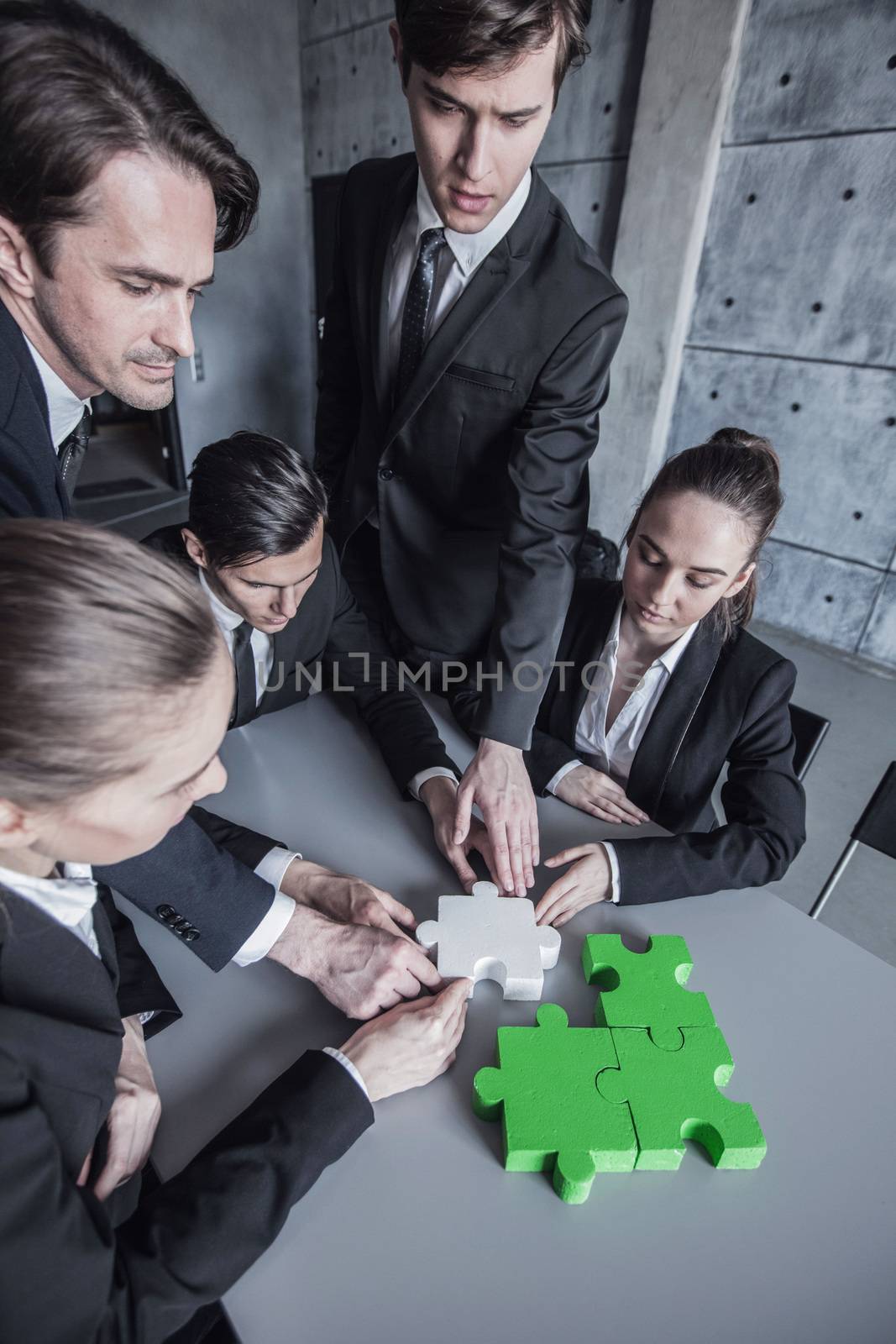 Business people assembling puzzle by ALotOfPeople