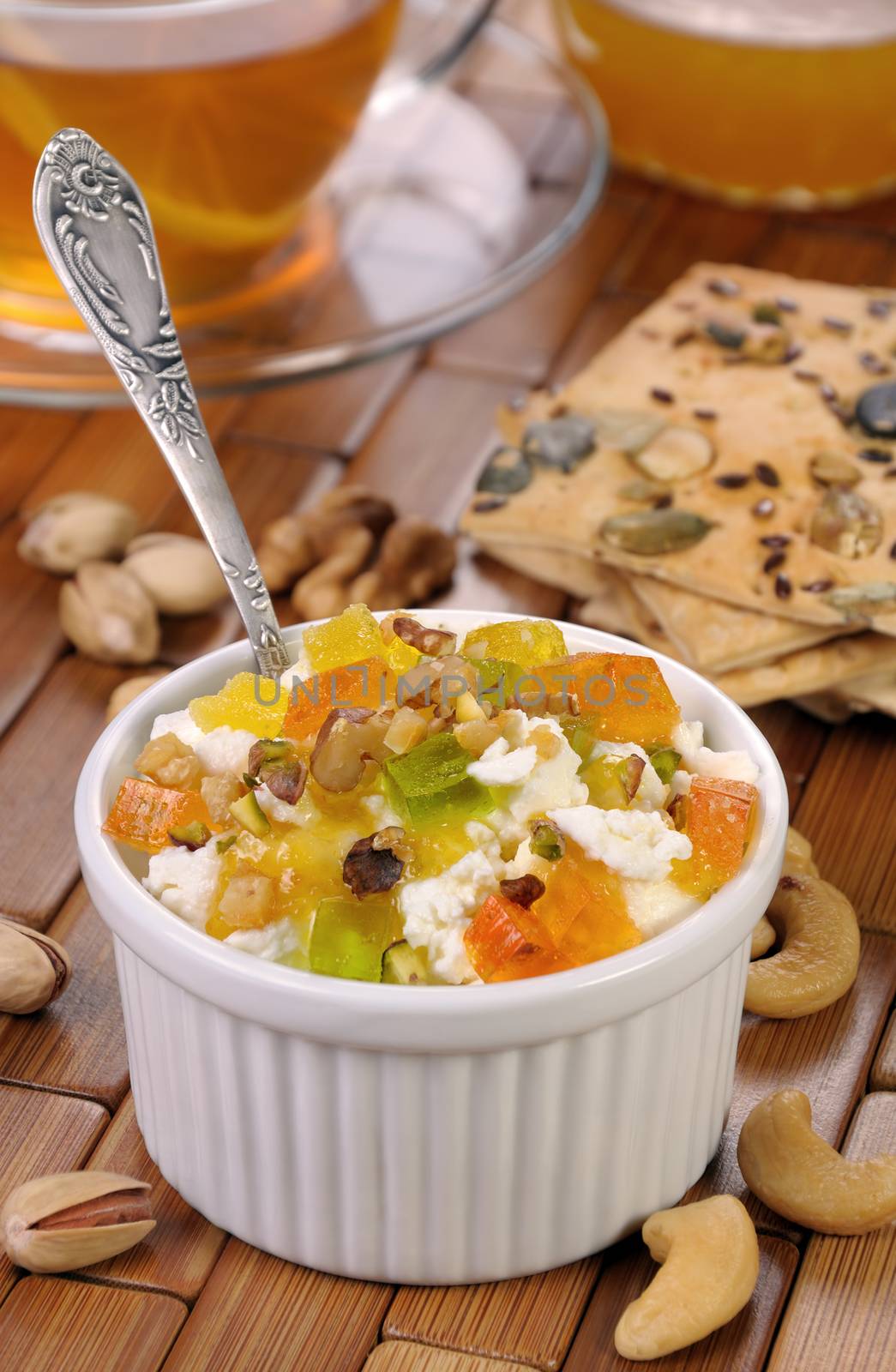 portion of cottage cheese with jam and marmalade slices, nuts, pistachios