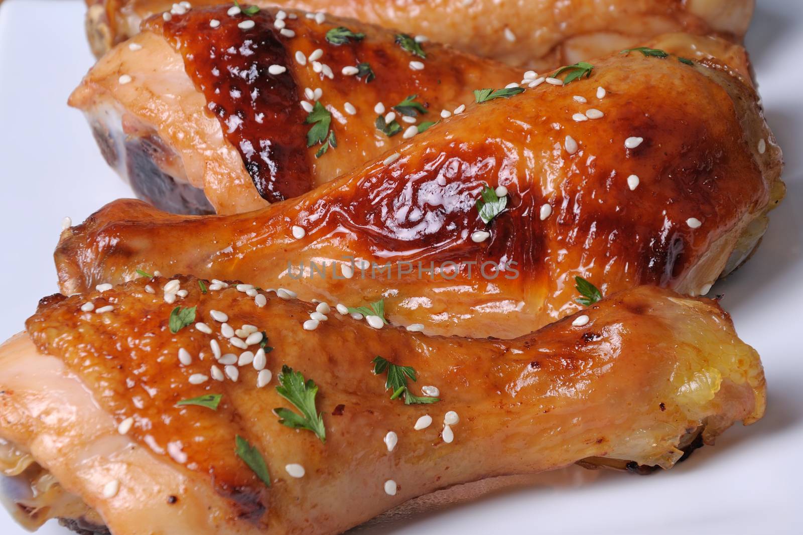 Fried chicken leg with sesame seeds in a plate closeup