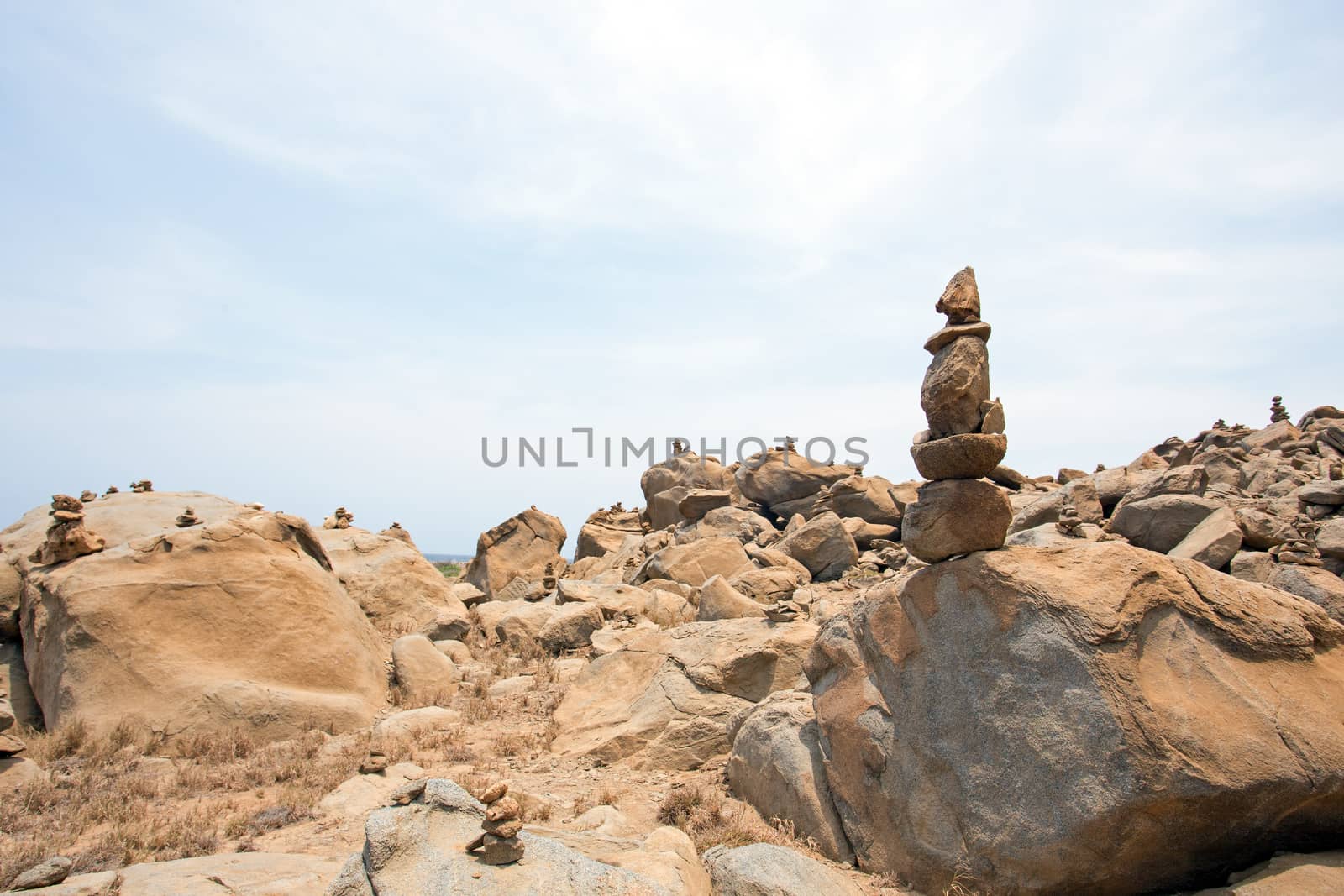 Stone pebbles stacked on the rocks on the beach in Aruba. An ancient ritual for good fortune and prosperity.