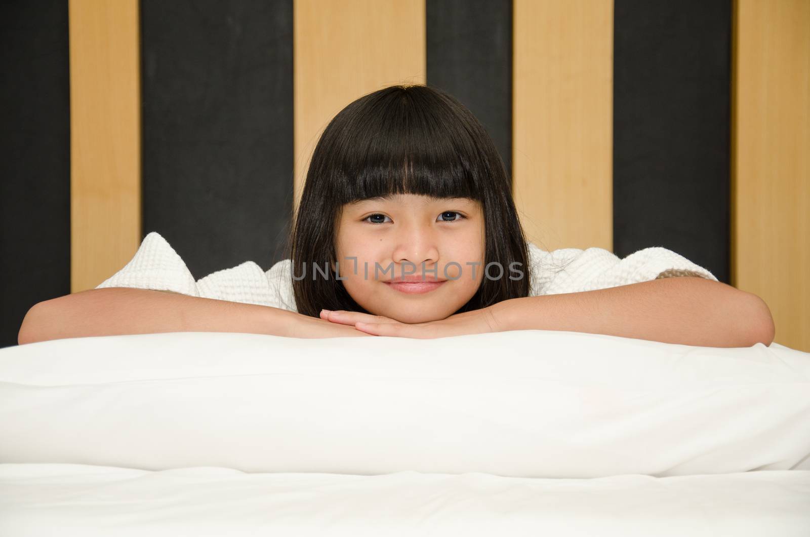 Adorable little asia girl waked up in her bed.