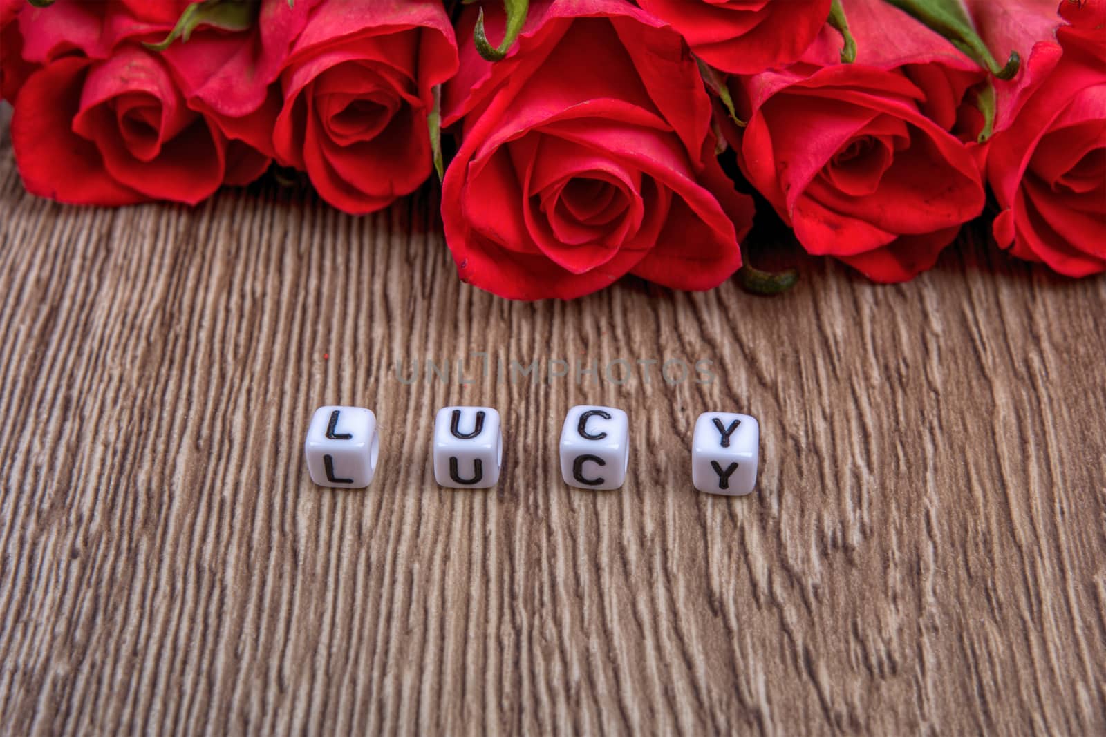 Cubes as a inscription Lucy on a wooden background by neryx