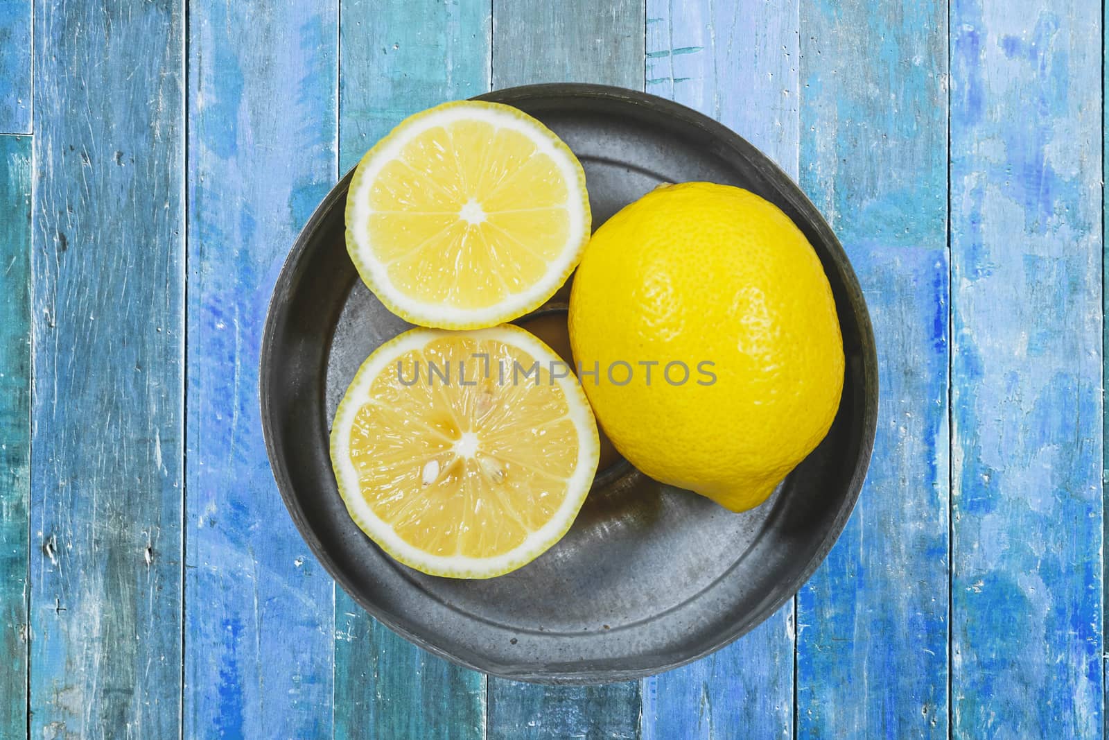 Sliced lemons isolated on blue wood background by nopparats