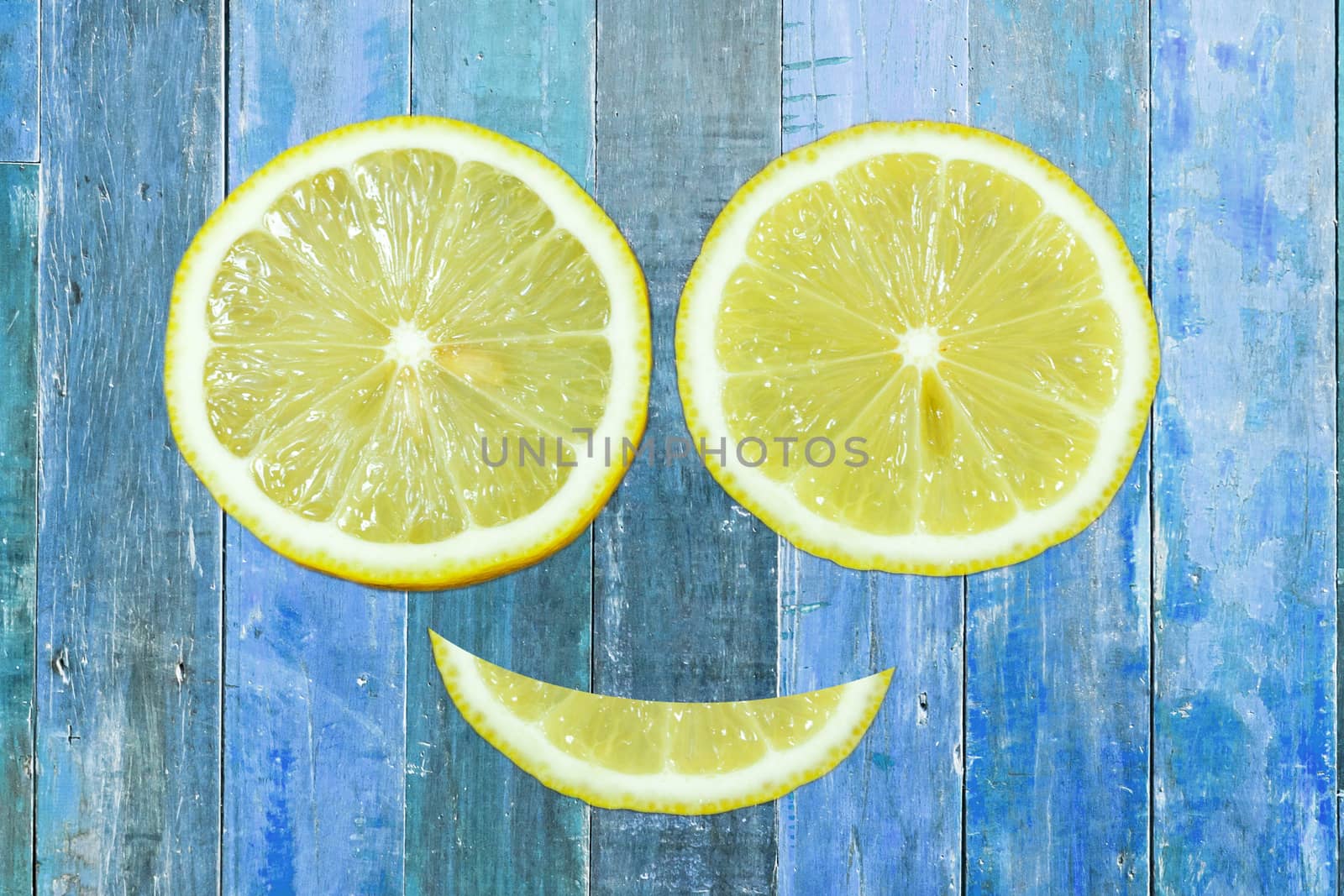 Sliced lemons isolated on blue wood background.