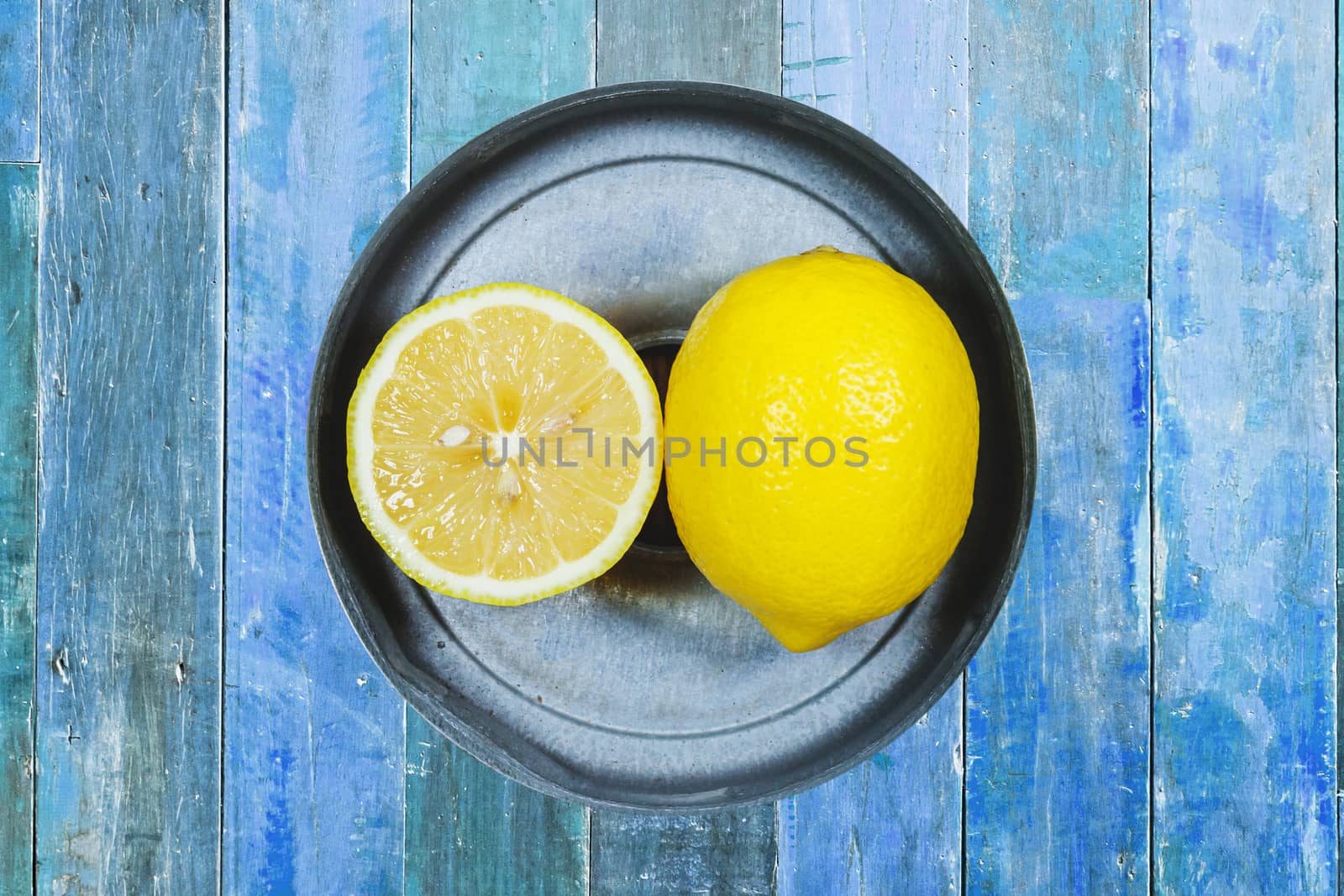 Sliced lemons isolated on blue wood background by nopparats