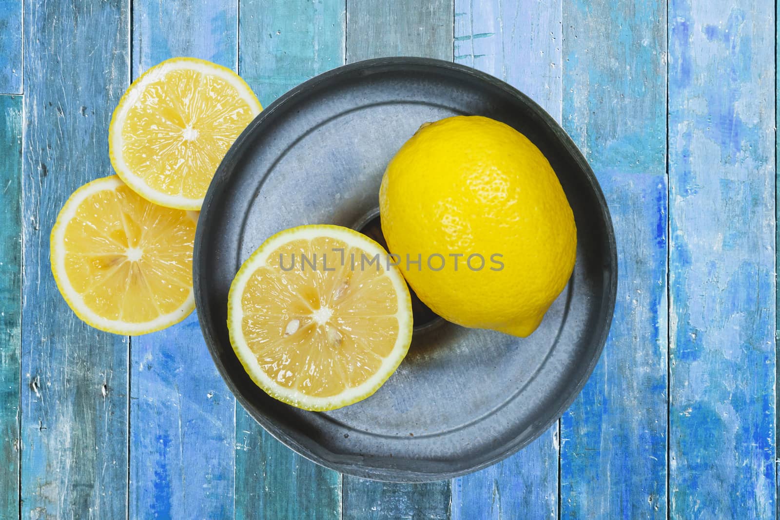 Sliced lemons isolated on blue wood background.