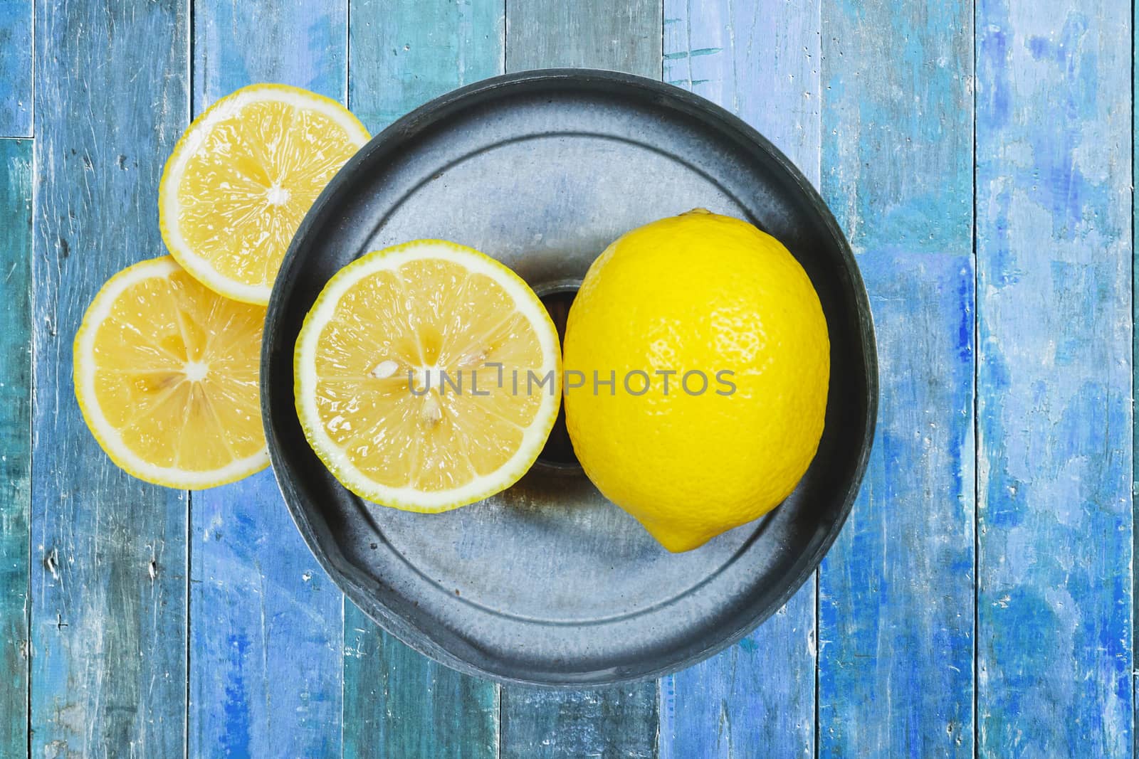 Sliced lemons isolated on blue wood background by nopparats