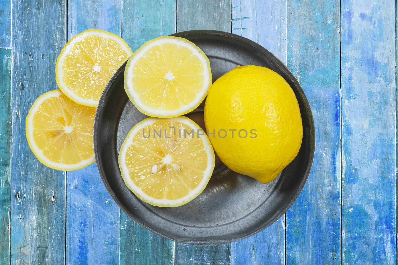 Sliced lemons isolated on blue wood background by nopparats