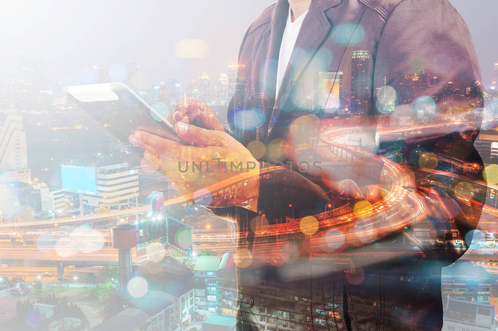 Double Exposure of Businessman use Tablet and Traffic on Highway in the City at Night