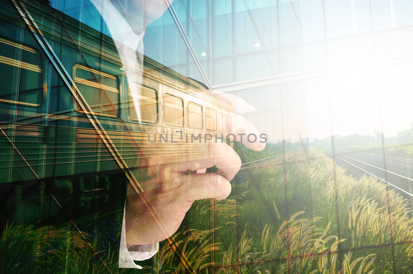 Double Exposure of Businessman writing, Glass decorated Building and Train on Rural Scene with sunrise as Conceptual image