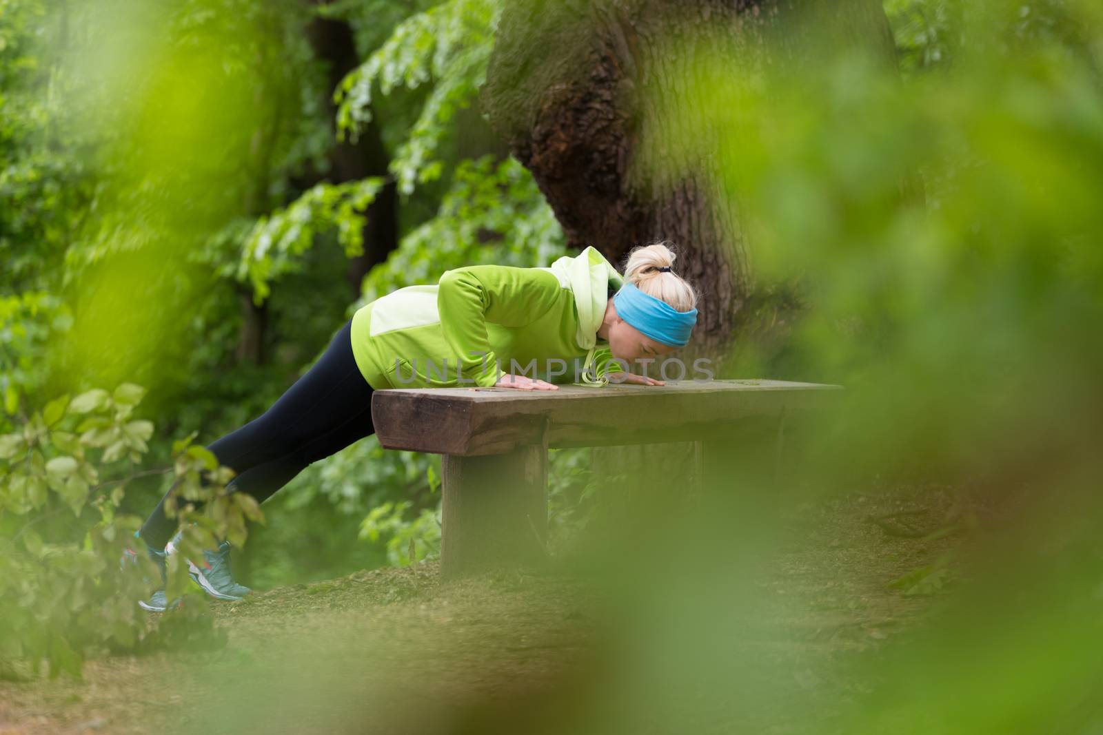 Sporty young female working out in forest.  Female runner during outdoor workout in nature. Fitness model outdoors. Weight Loss. Healthy lifestyle. 