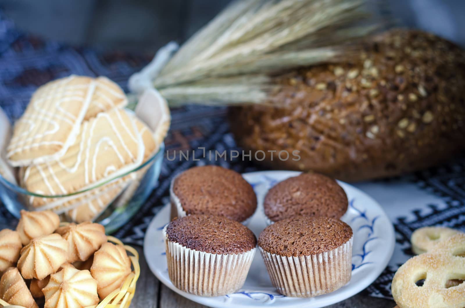 Various kinds of bread and rye ears on the old Board and a towel, rustic style, bokeh