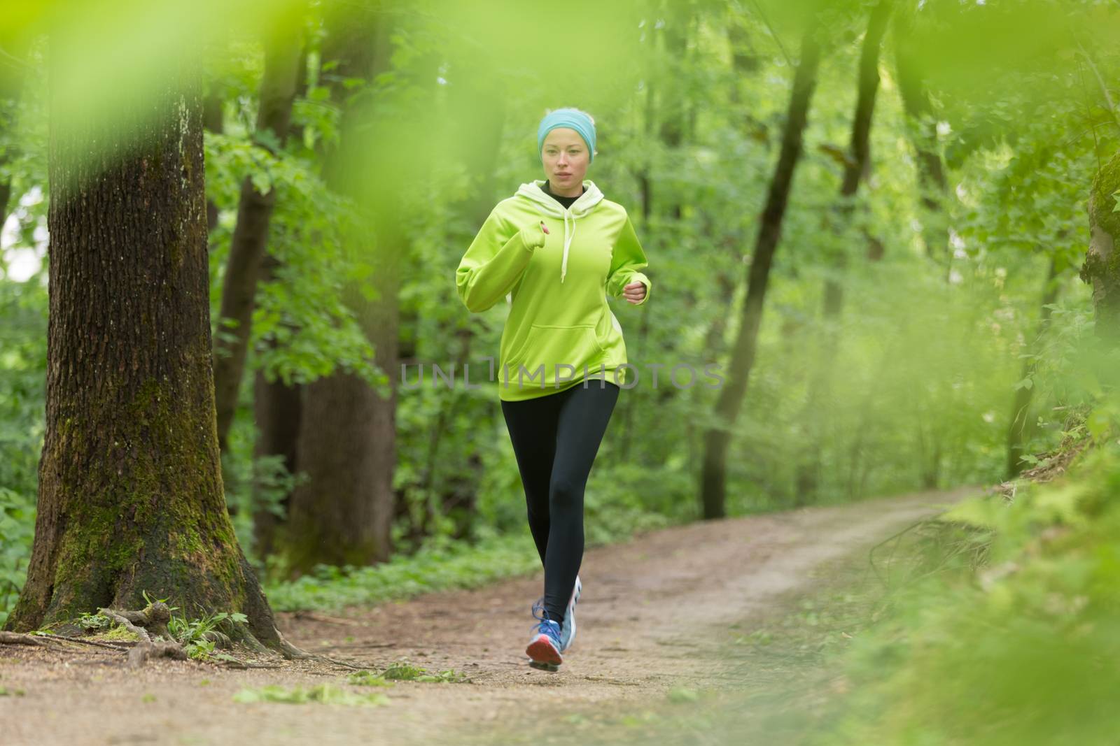 Sporty young female runner in forest.  Running woman. Female runner during outdoor workout in nature. Fitness model outdoors. Weight Loss. Healthy lifestyle. 