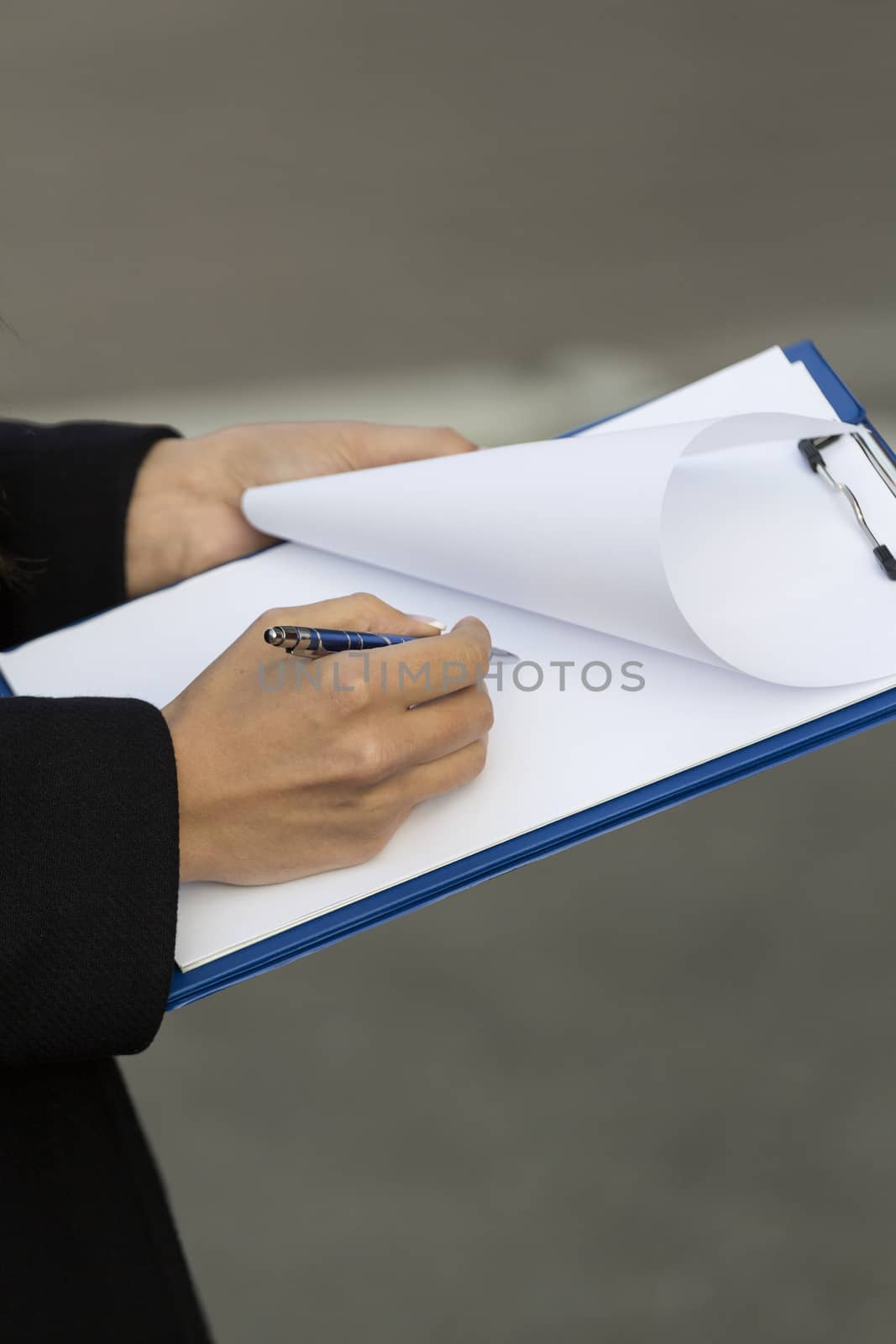 the girl in the black coats in the hands of the clip board