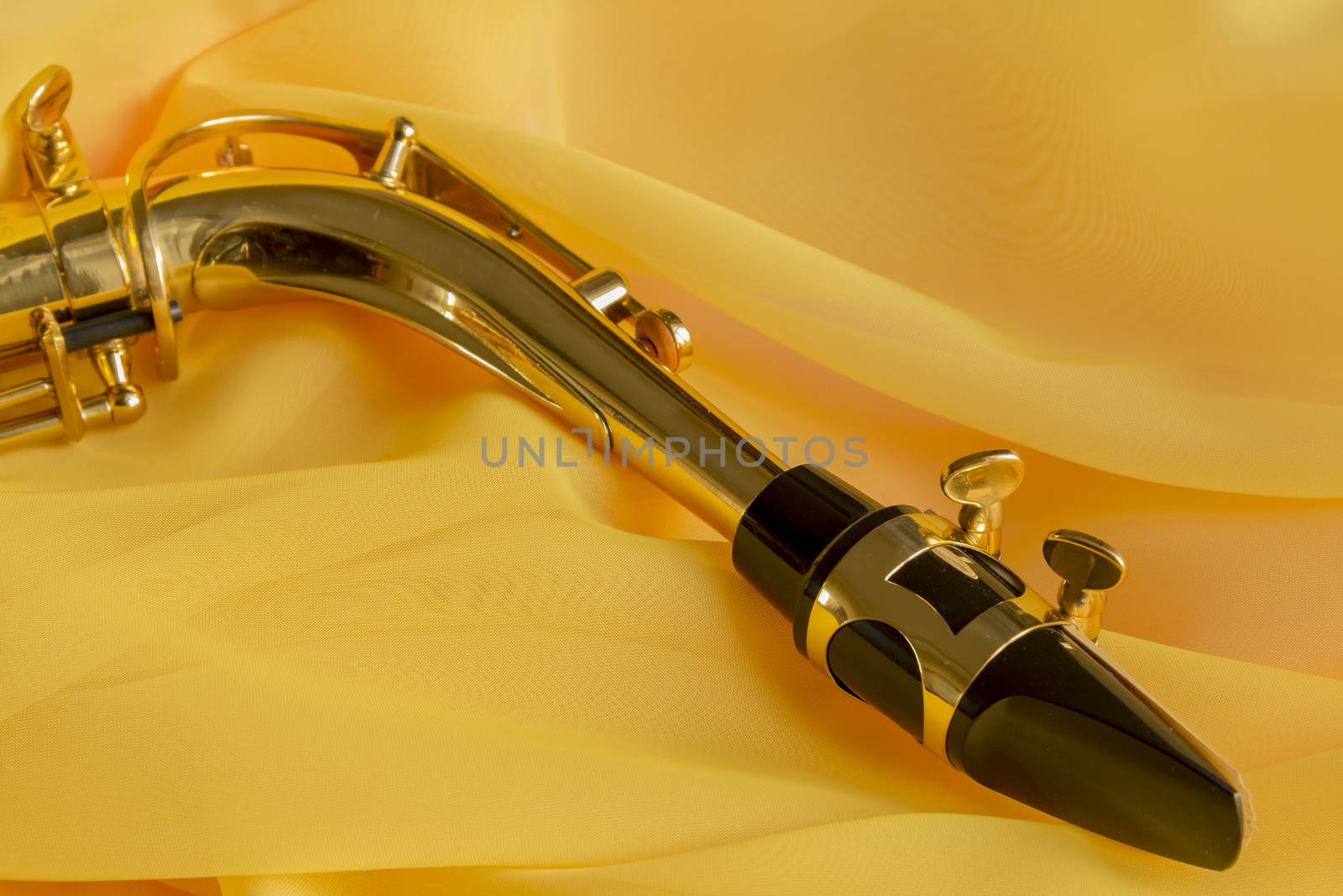 beautiful golden saxophone on delicate Yellow silk background