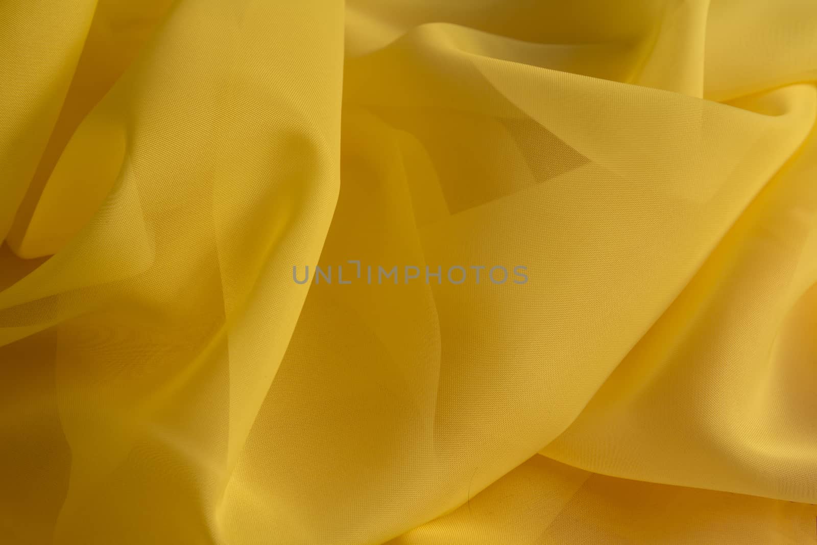 Shiny Yellow silky fabric folds background texture