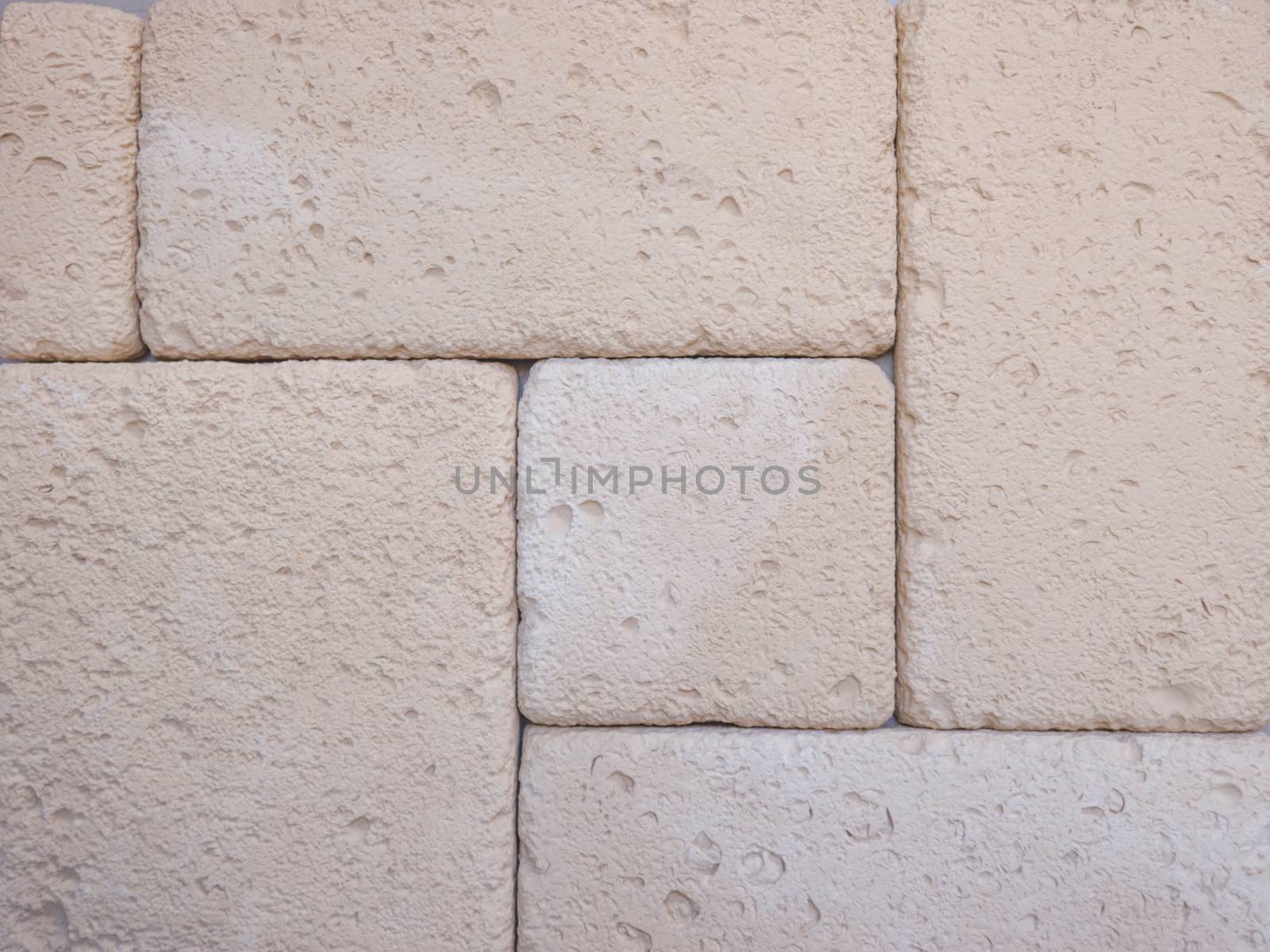 a wall from an artificial gray stone facade with rough fractured surfaces