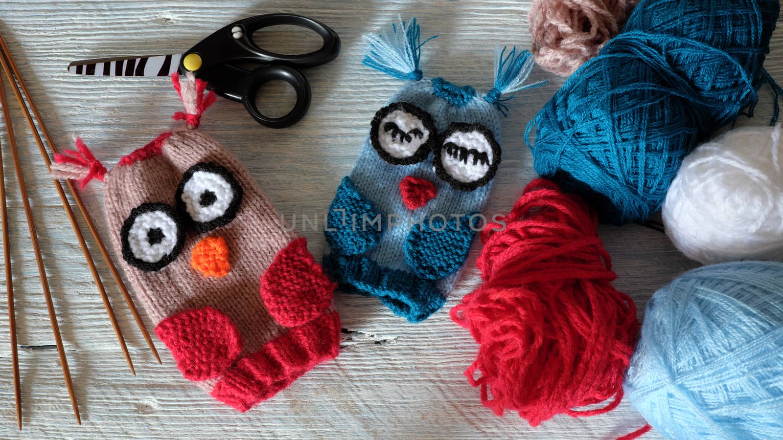 Hand puppets for children day, colorful owl puppet knit from yarn, funny handmade gift for child day on white wooden background