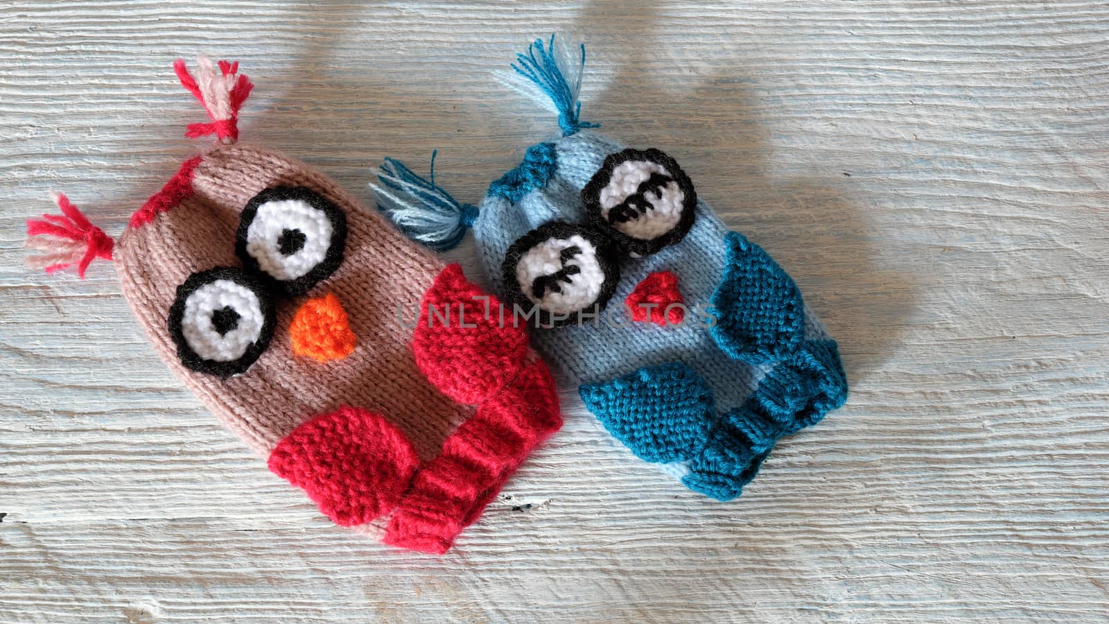 Hand puppets for children day, colorful owl puppet knit from yarn, funny handmade gift for child day on white wooden background