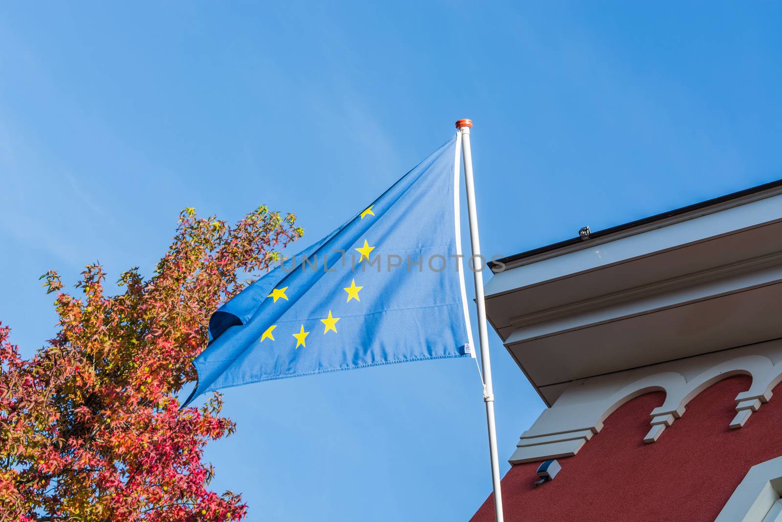 EU flag in front of an old building in the background a blue sky