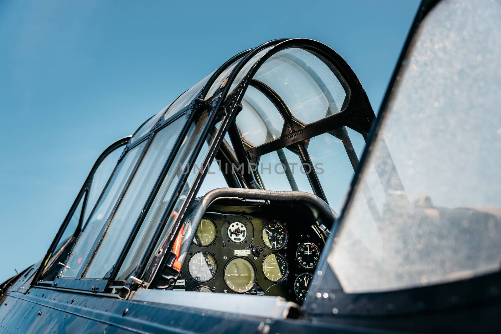 Open vintage airplane cockpit, blue sky background. 