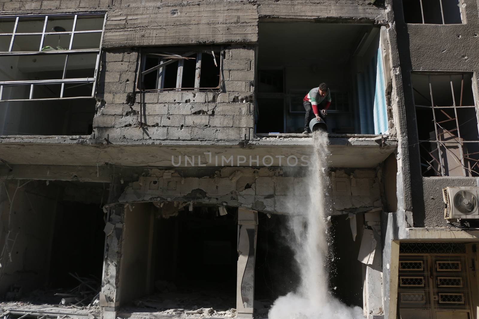 SYRIA, Saqba : A resident of the city of Saqba cleans a destroyed building of the city of East suburb of Damascus, the capital city of Syria, on December 28, 2015. Regime forces fired rockets on the towns of Douma, Harasta, Saqba and Arbin in the opposition-held Eastern Ghouta region on December 13, 2015 according to the Syrian Observatory for Human Rights. At least 45 people were killed during these attacks, according to the NGO. 
