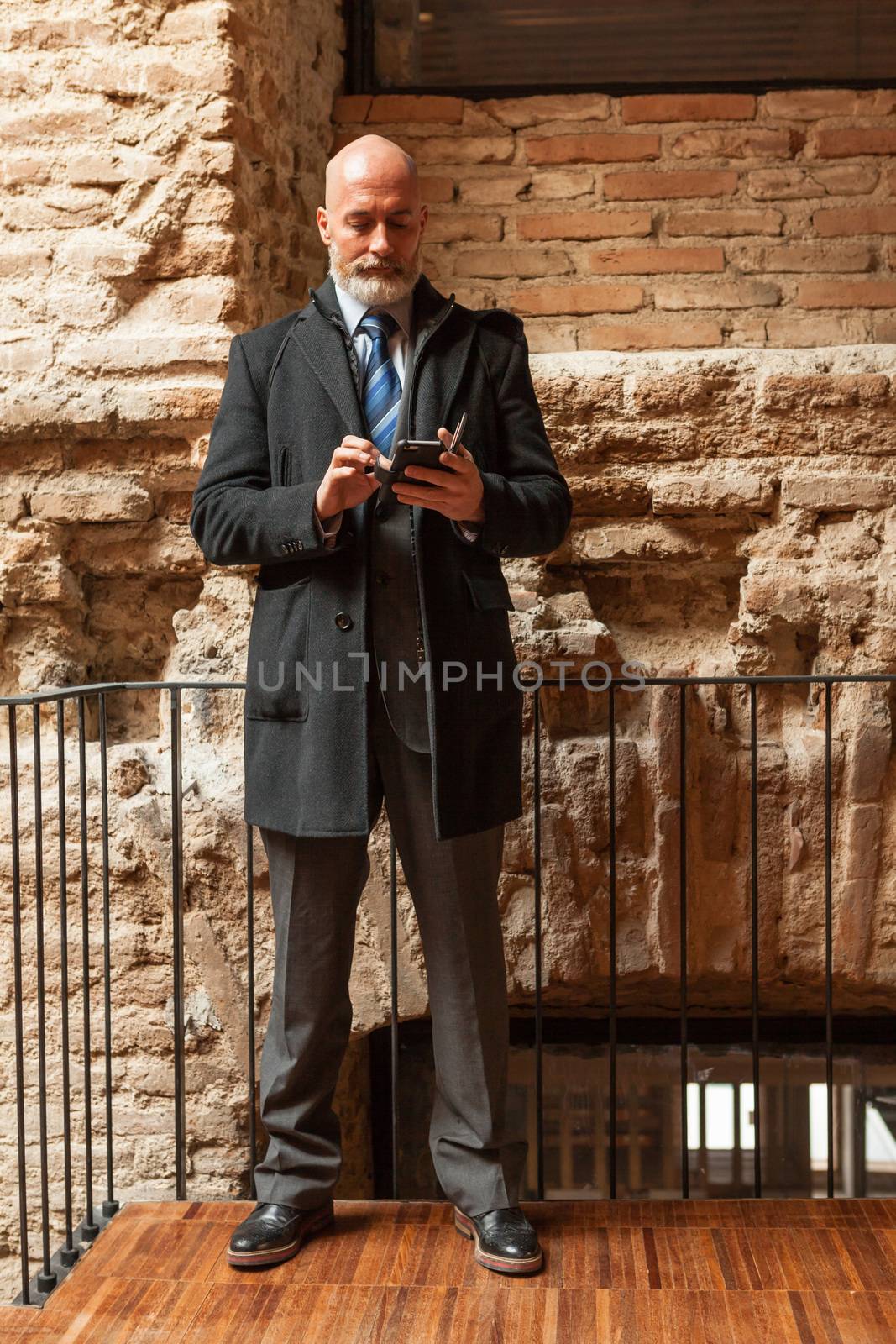 Businessman middle-aged bearded and suit jacket searching on tablet on a blurred background