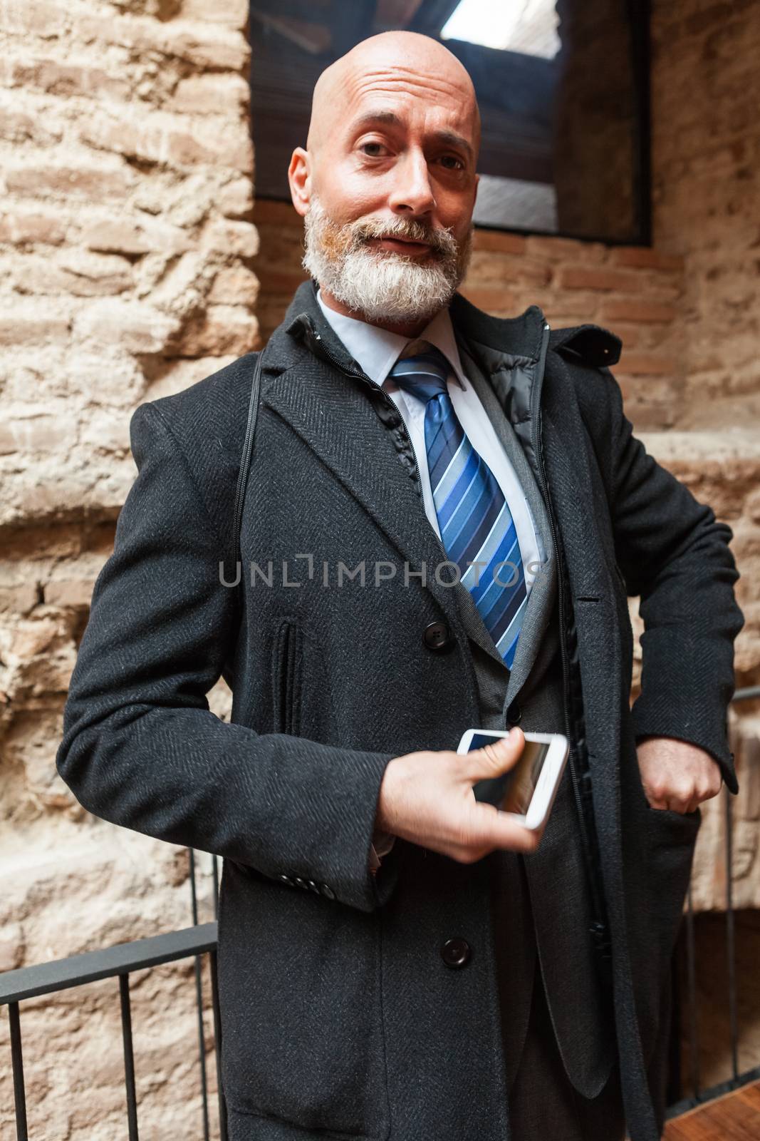 Businessman middle-aged bearded and suit jacket searching on tablet on a blurred background