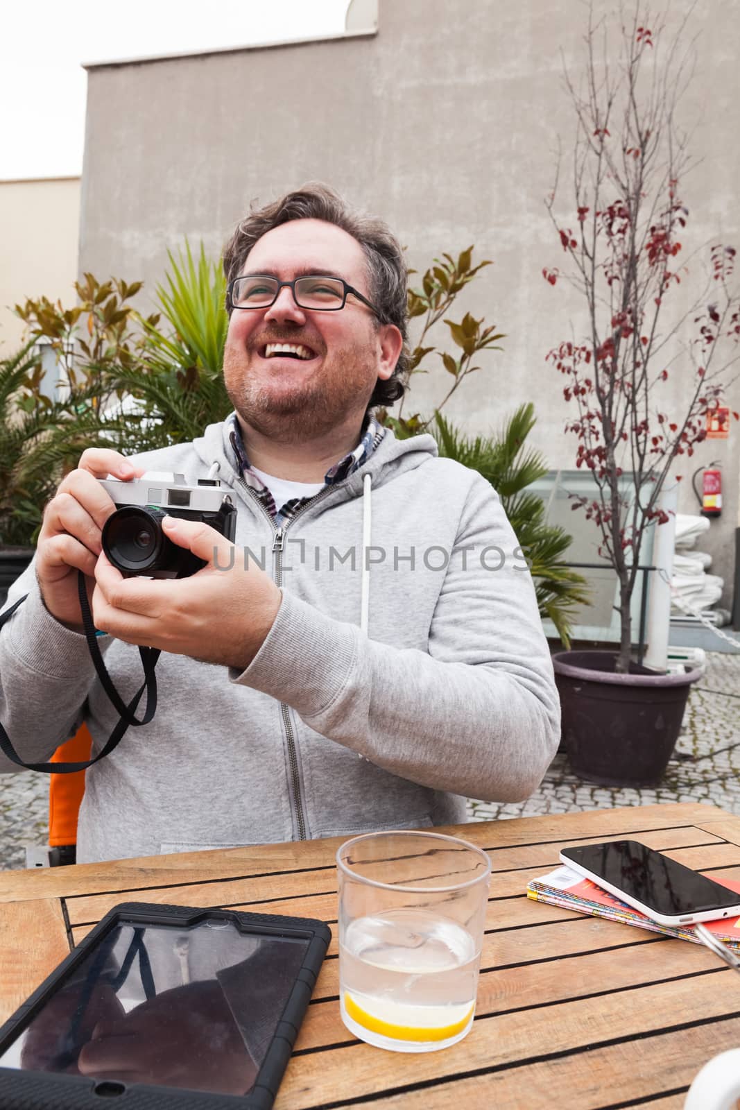 Happy young man traveler shooting with a vintage camera by andongob