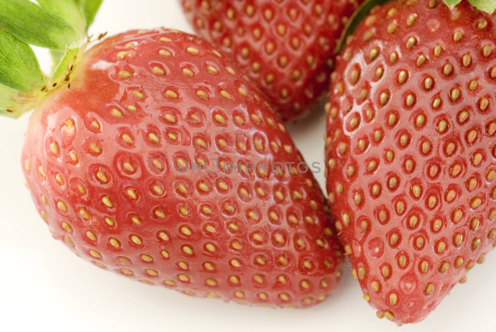 Extreme close up on three fresh strawberries by stockarch