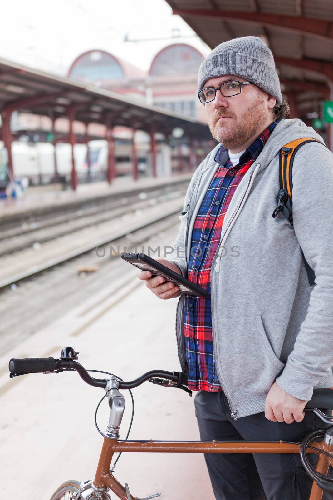 Hipster young man carrying a bicycle on the train by andongob