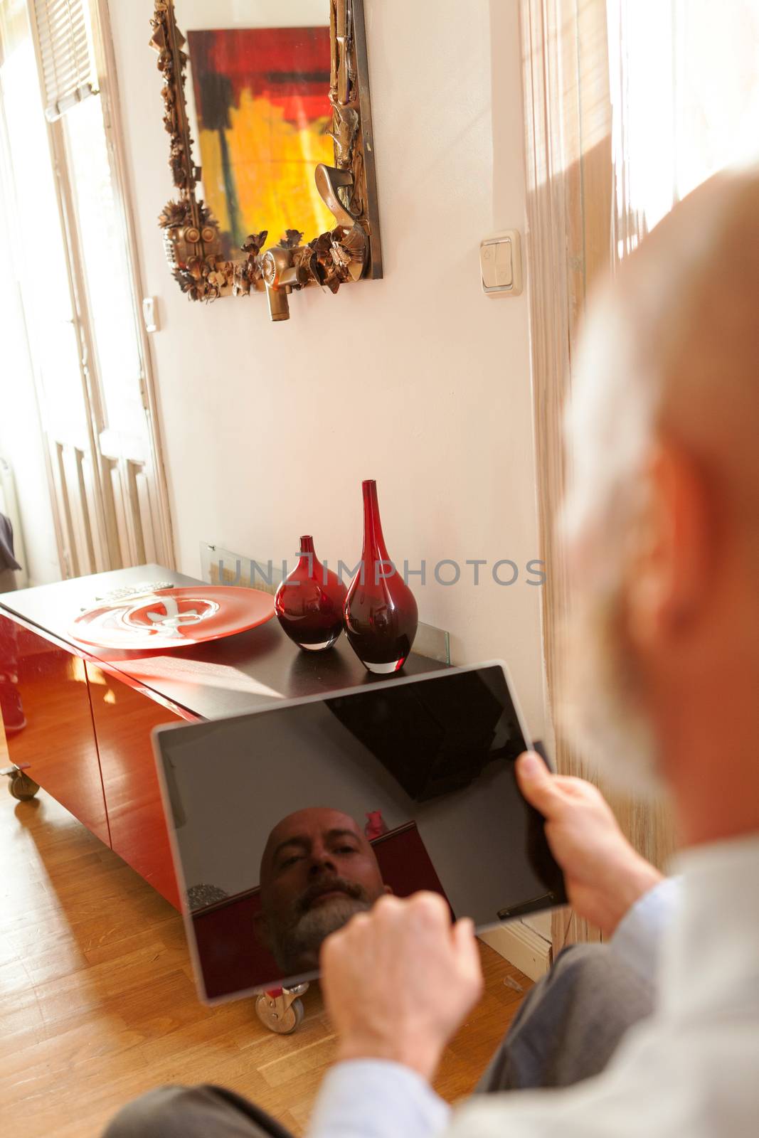 Businessman middle-aged working from home with a tablet by andongob