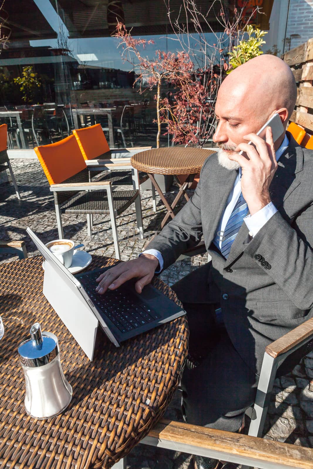 Middle-aged man , handsome and elegant working outside the office in a relaxed atmosphere