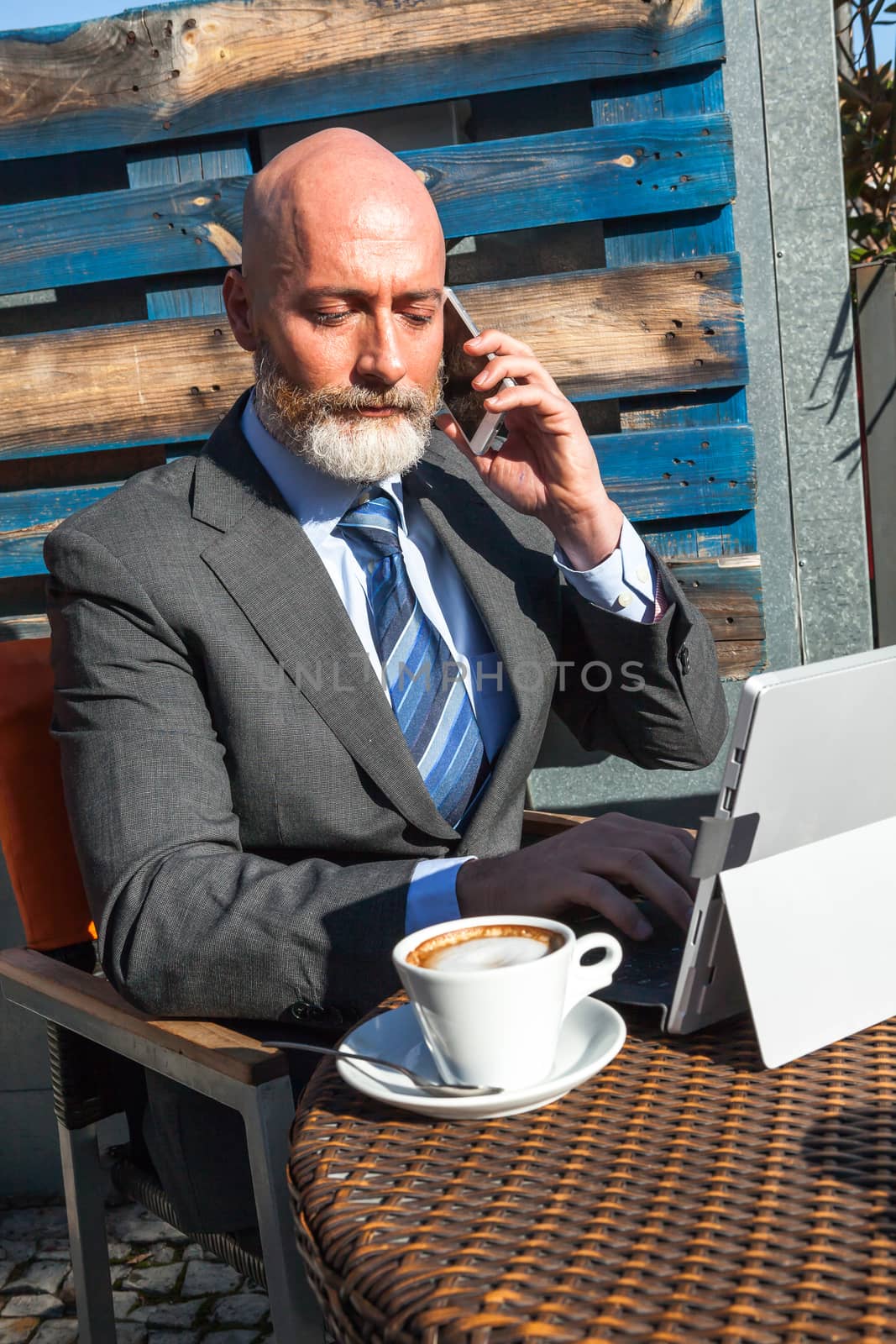 Middle-aged man , handsome and elegant working outside the office in a relaxed and atmosphere
