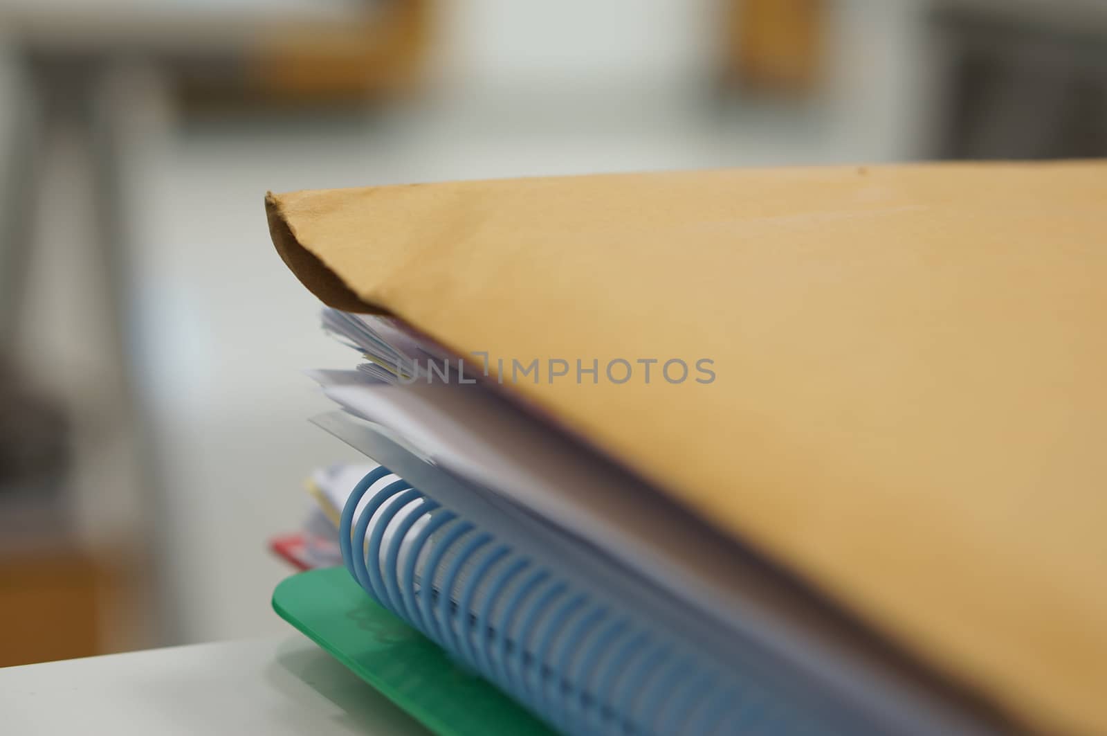 Brown paper container was place upper stack of document and binder notebook.