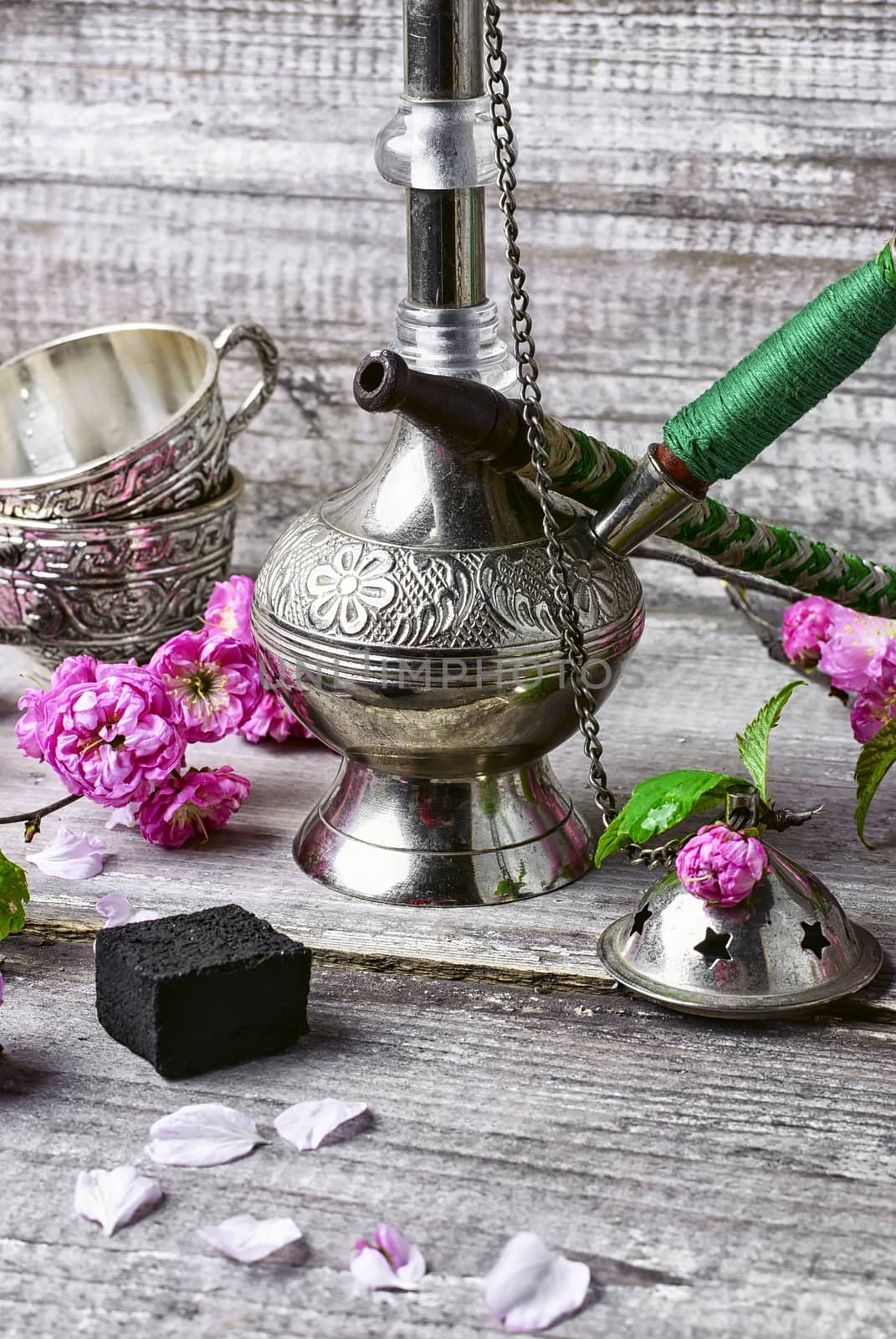 Arab hookah metal and scattered tobacco leaf