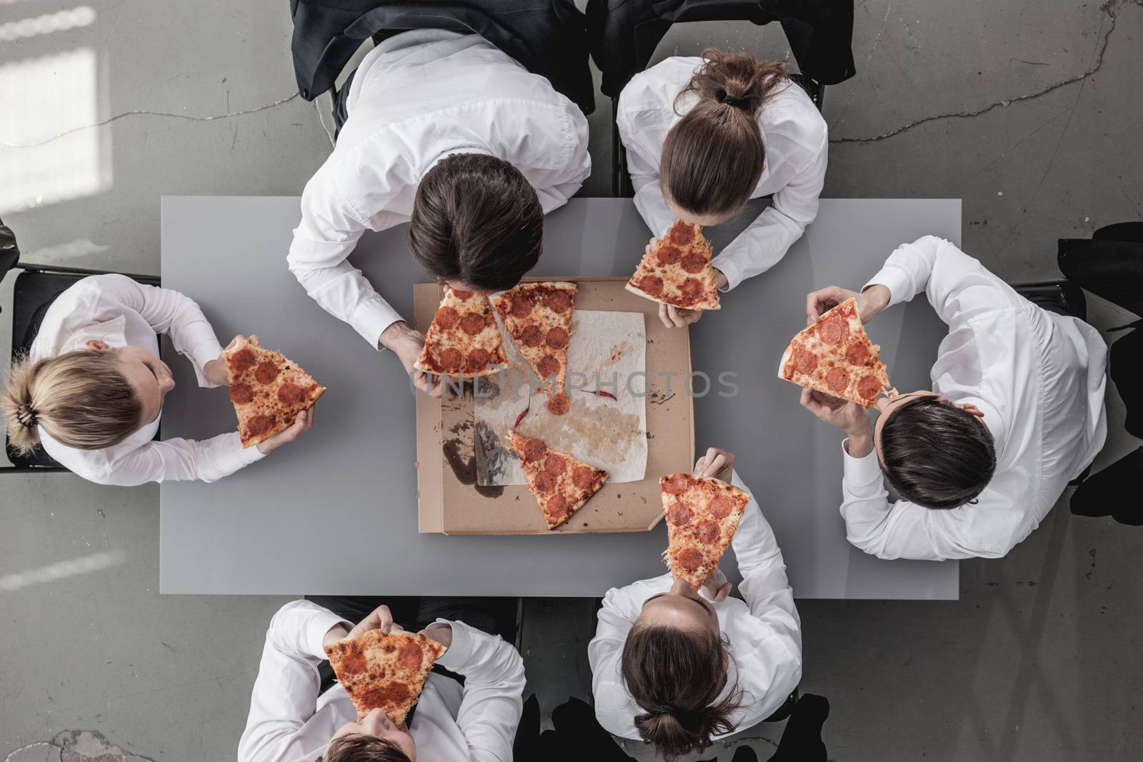 Business team eating pizza by ALotOfPeople