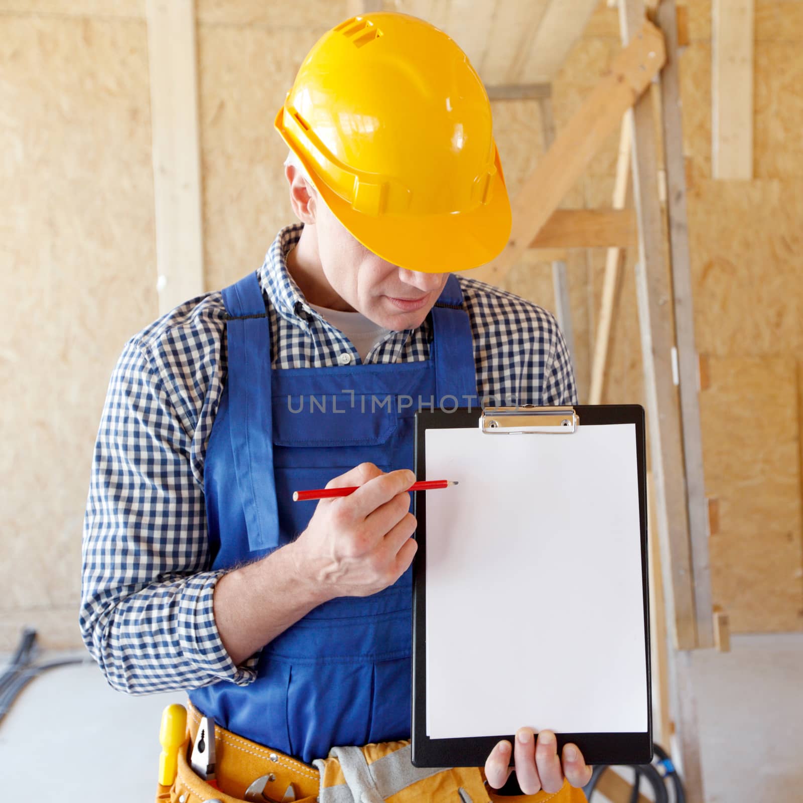 Portrait of foreman pointing at white folder plate