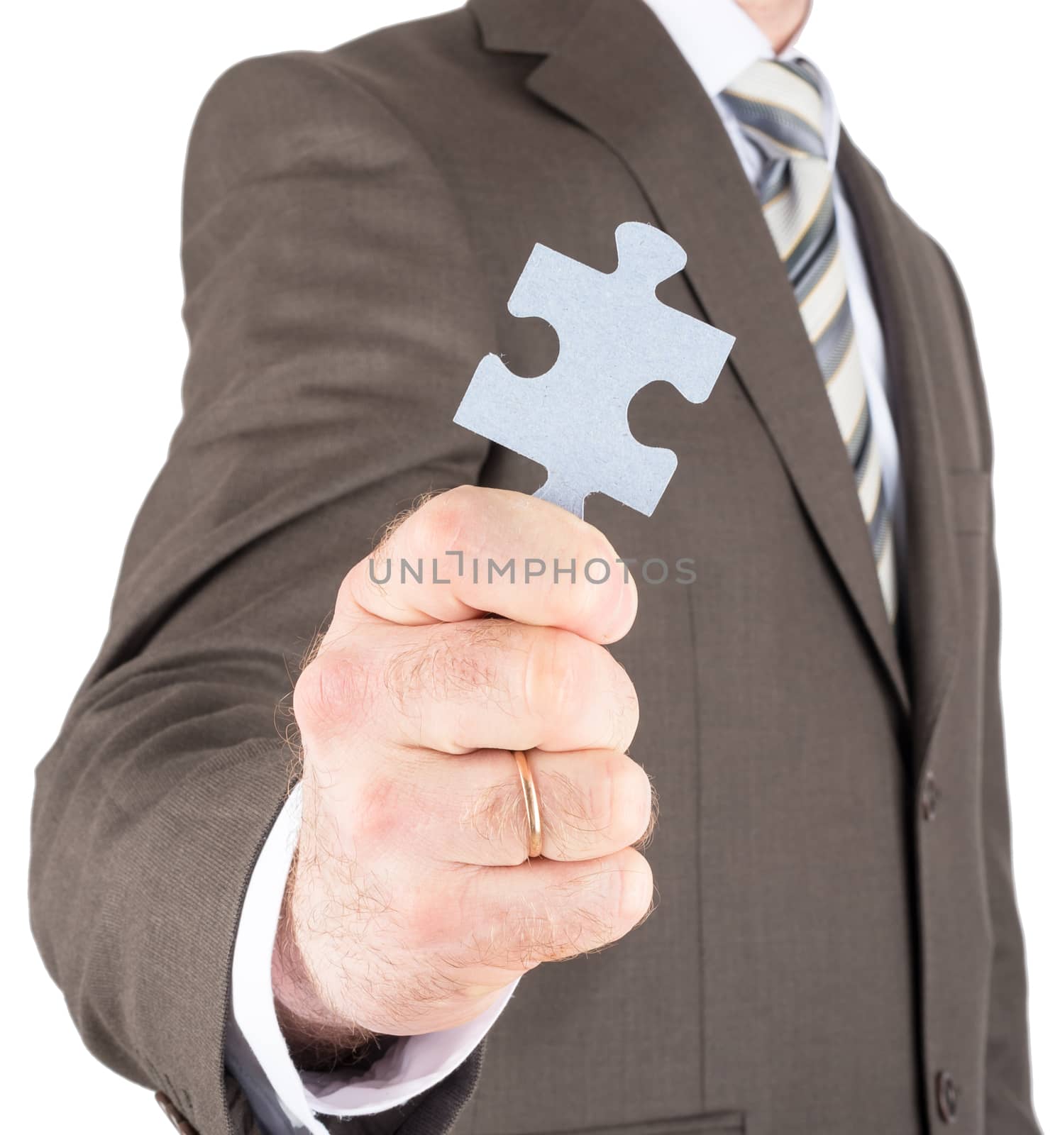 Businessman or innovator holding blank puzzle piece towards you isolated on white background